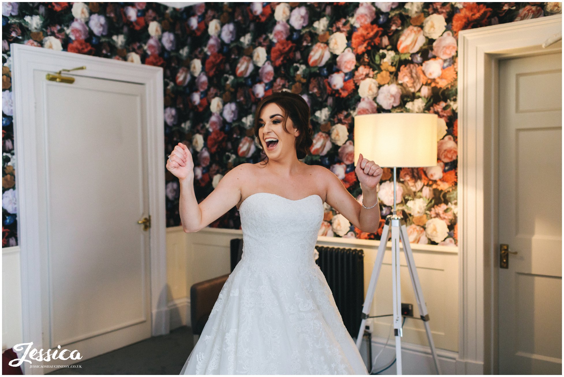 the bride cheers as she puts on her wedding dress