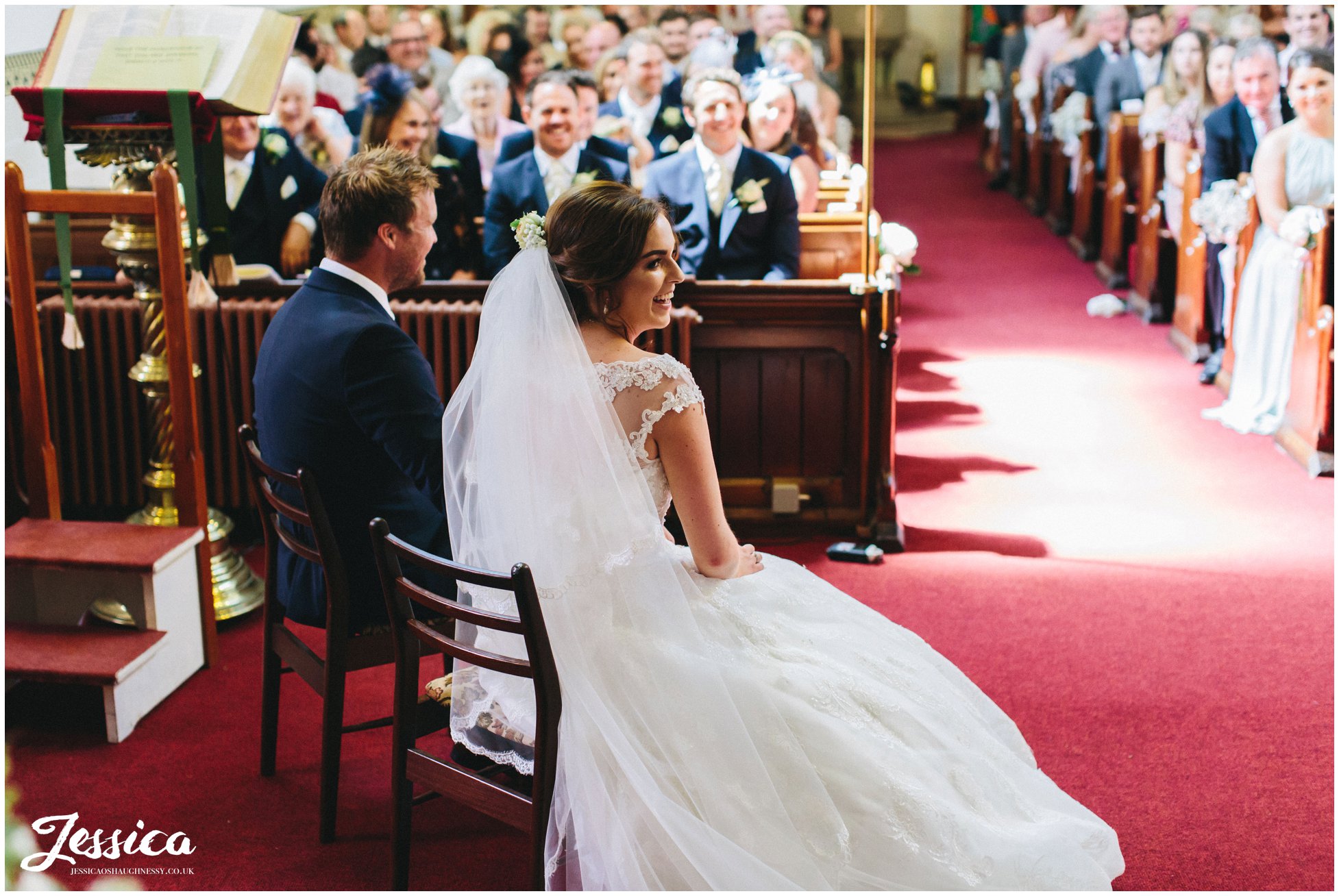 bride smiles as the reverend gives his sermon