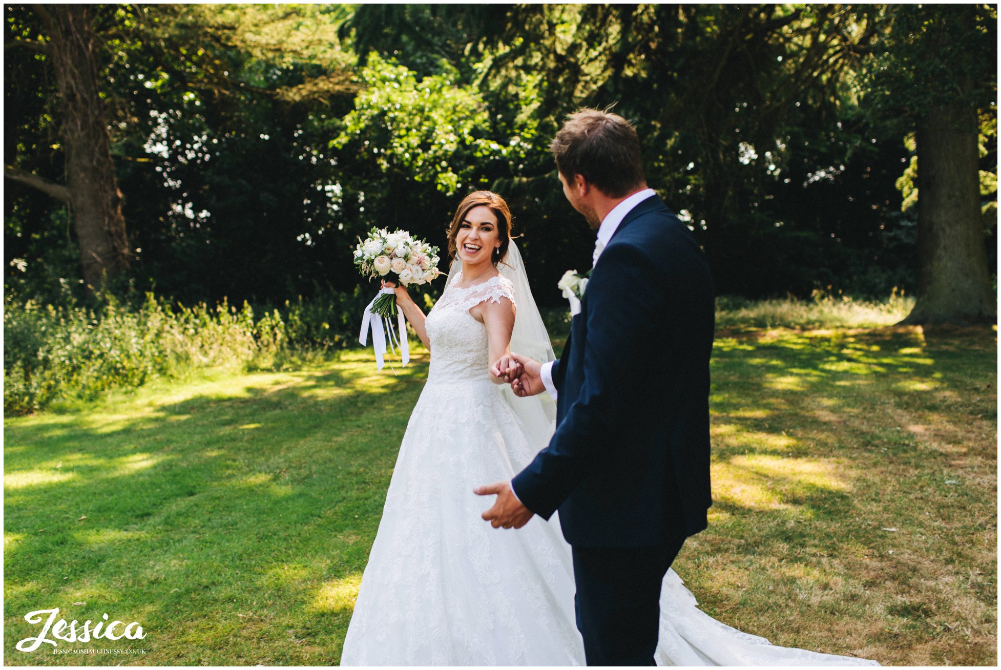 bride laughs at her groom as they walk through bartle hall's grounds