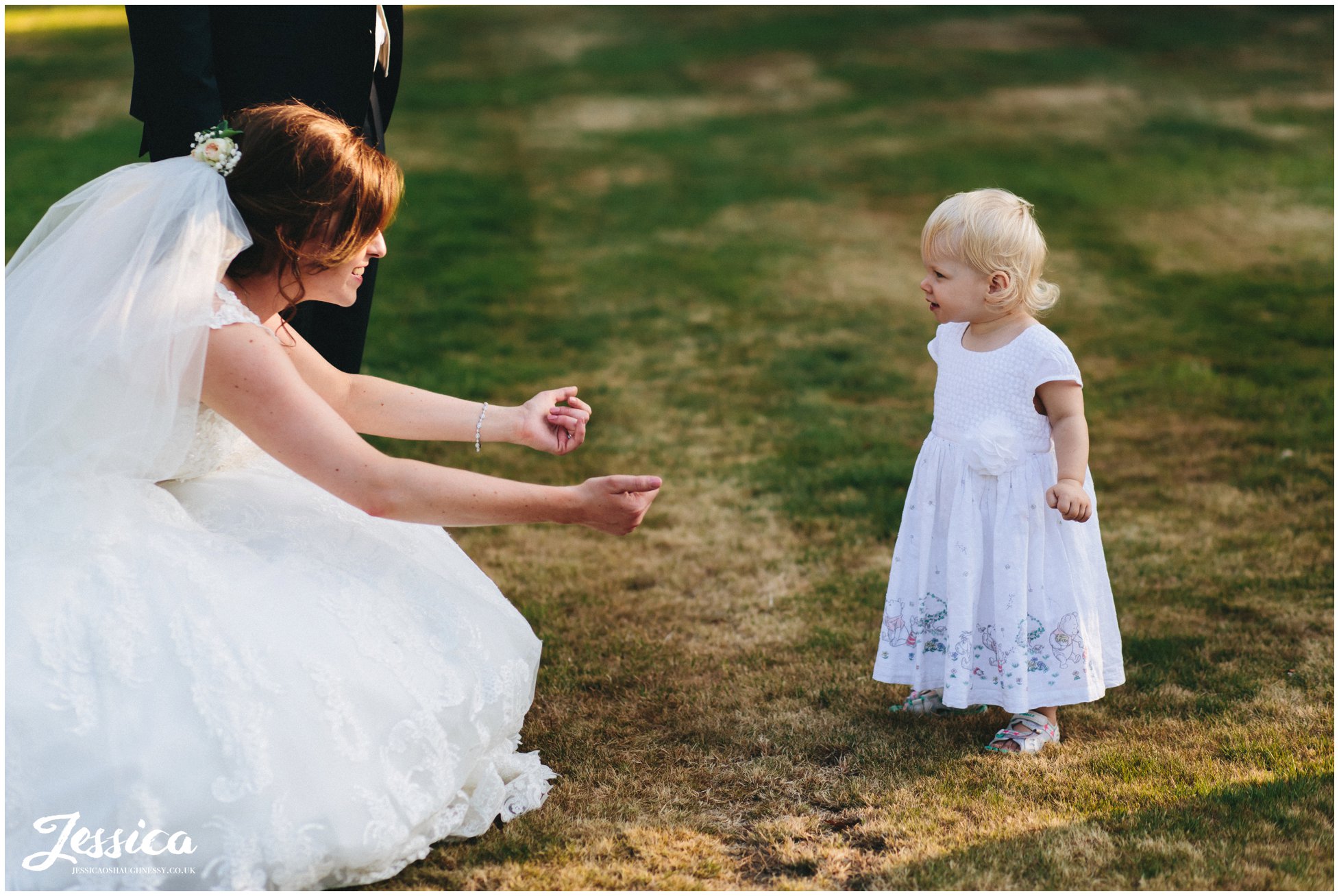 bride puts her arms out to hug the flower girl