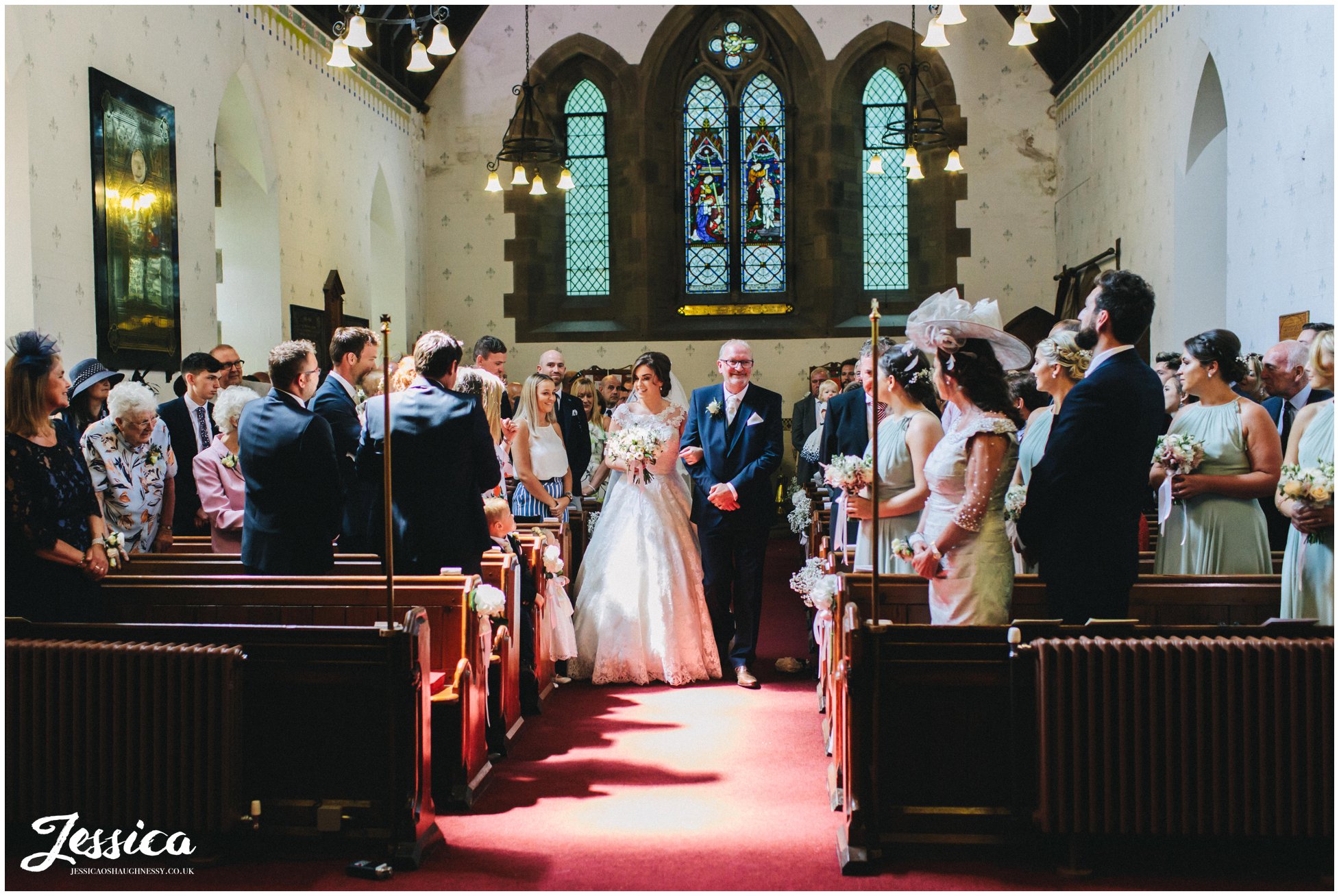 bride walks down the aisle with her father