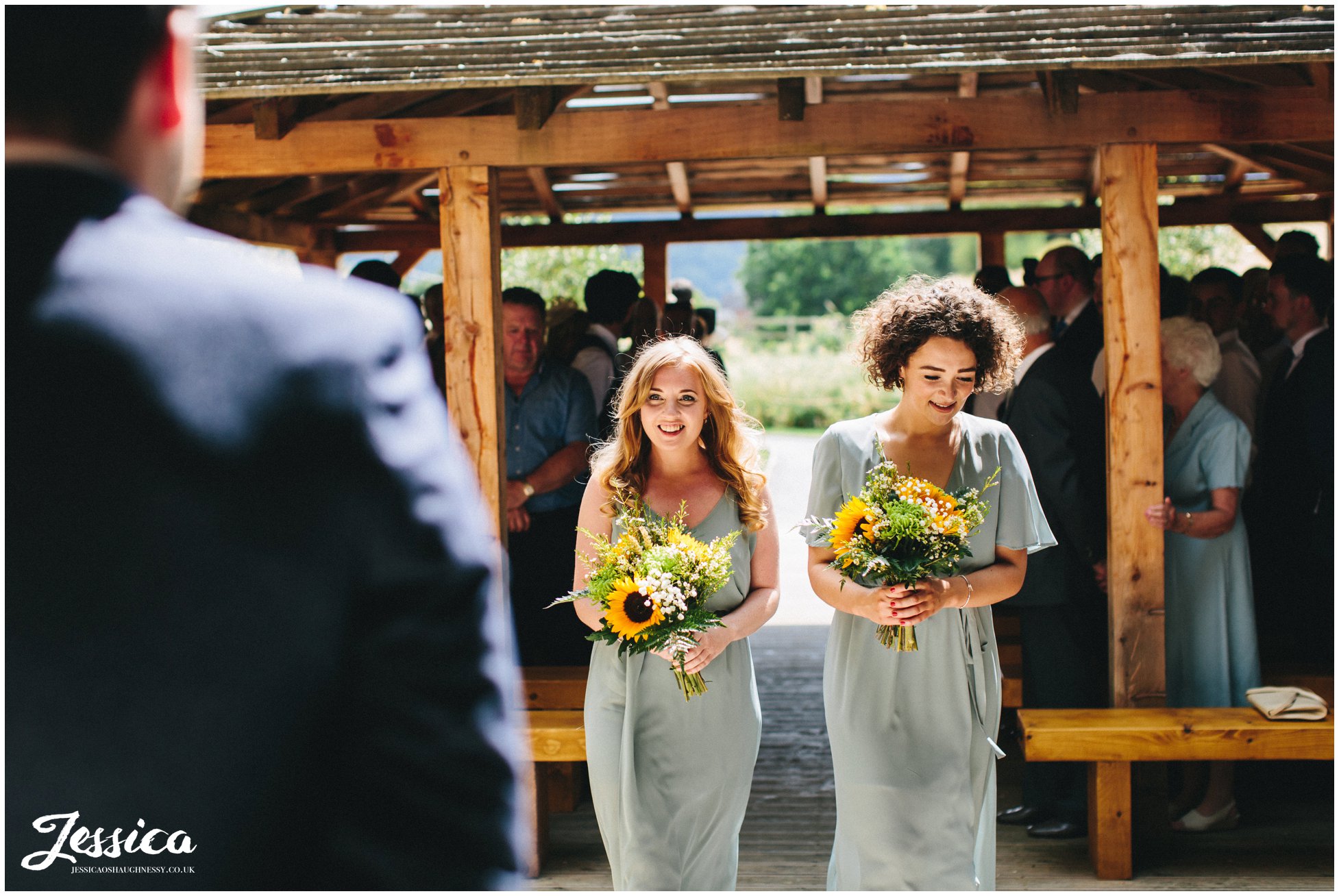 bridesmaids walk down the aisle ahead of the bride