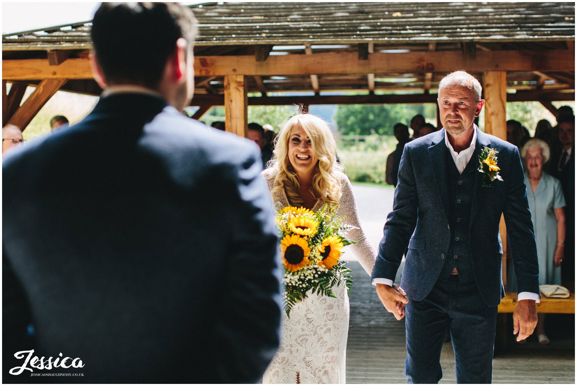 the bride smiles at the groom as she meets him under the bridge