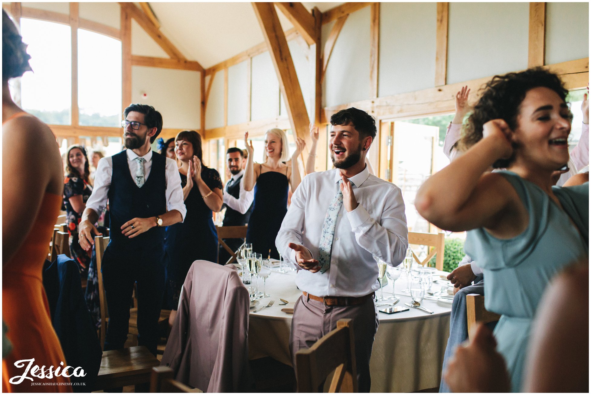 guests clap as they welcome in the new couple