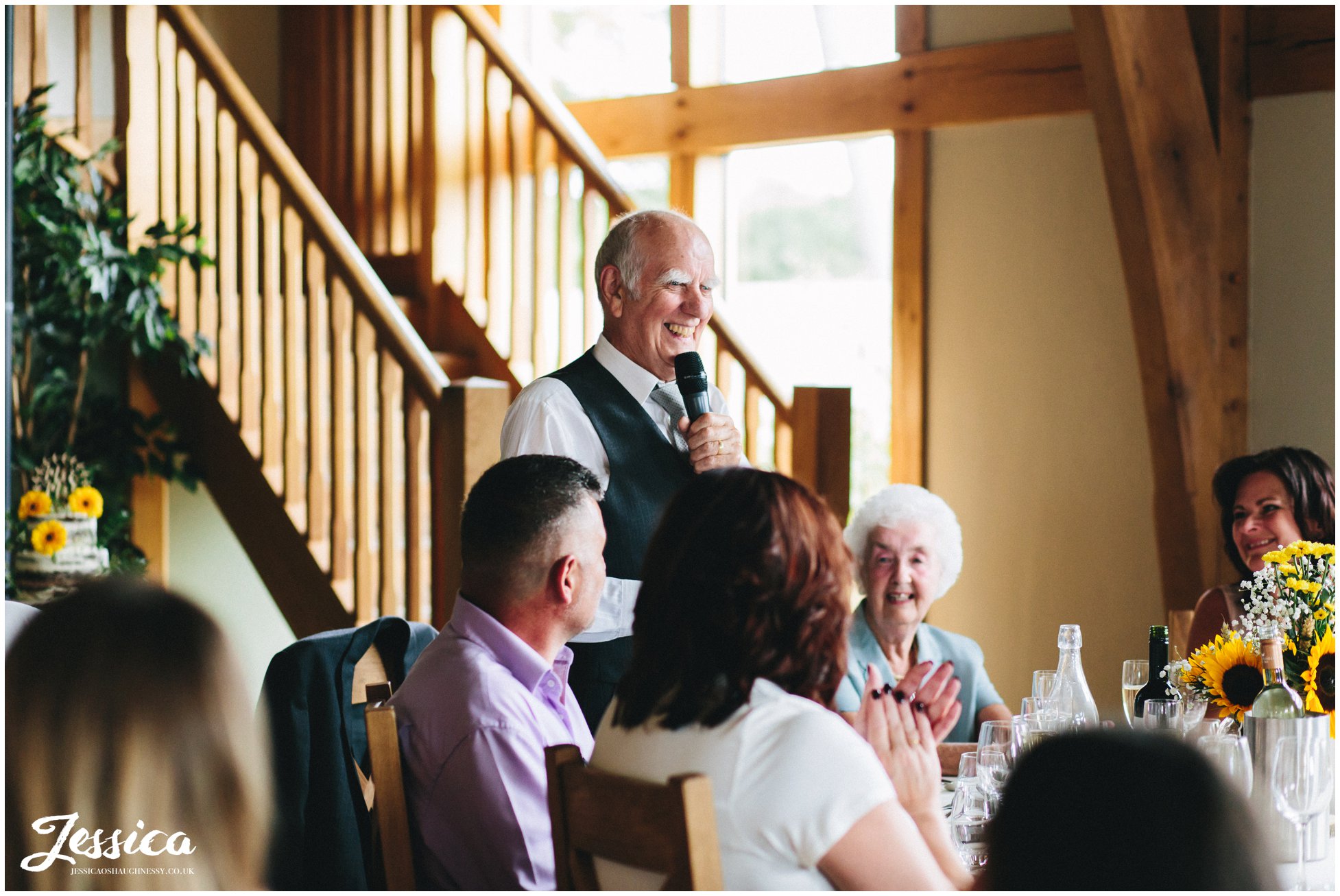 the brides grandfather makes a speech at the wedding reception