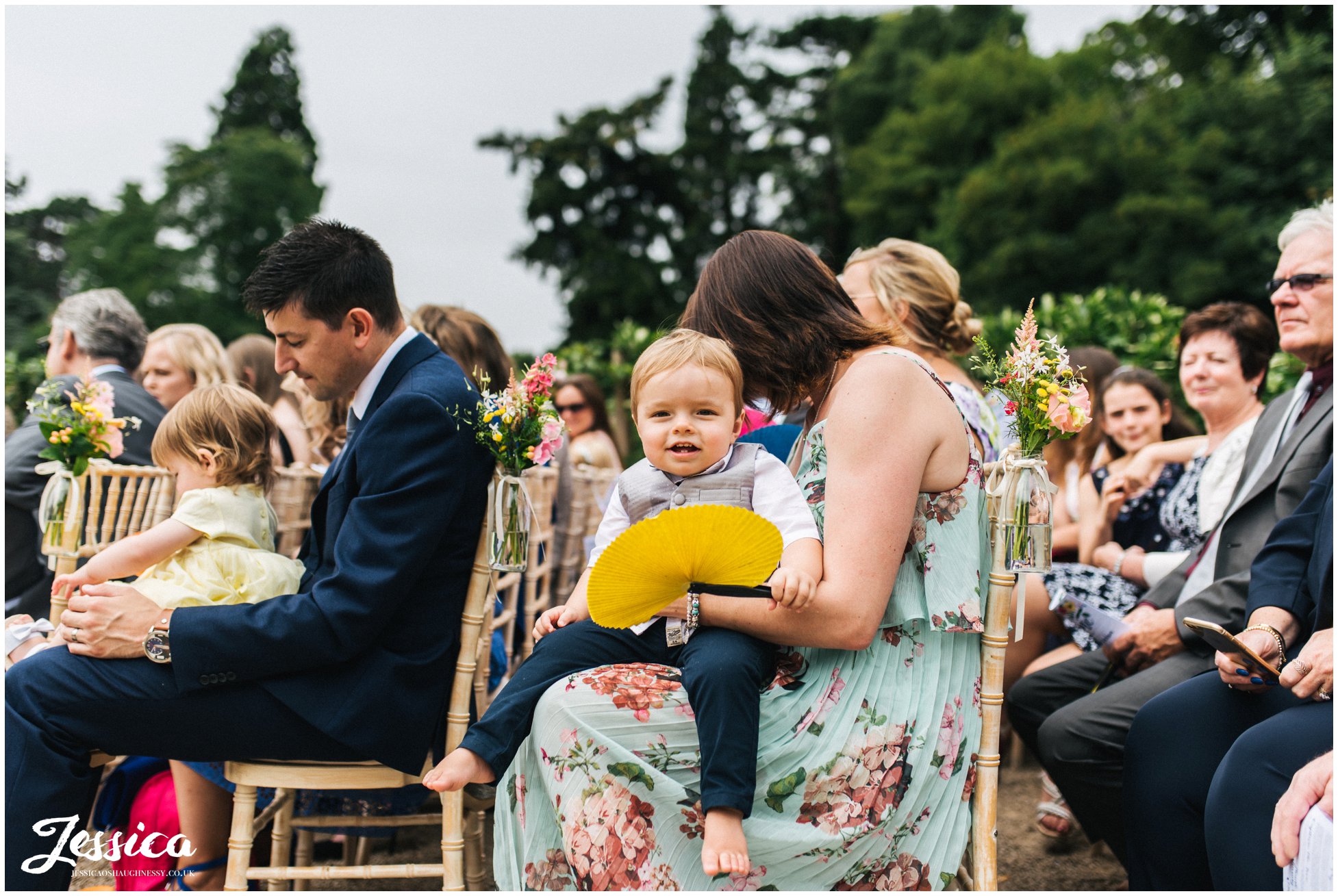 child sits on his mothers knee for the wedding service