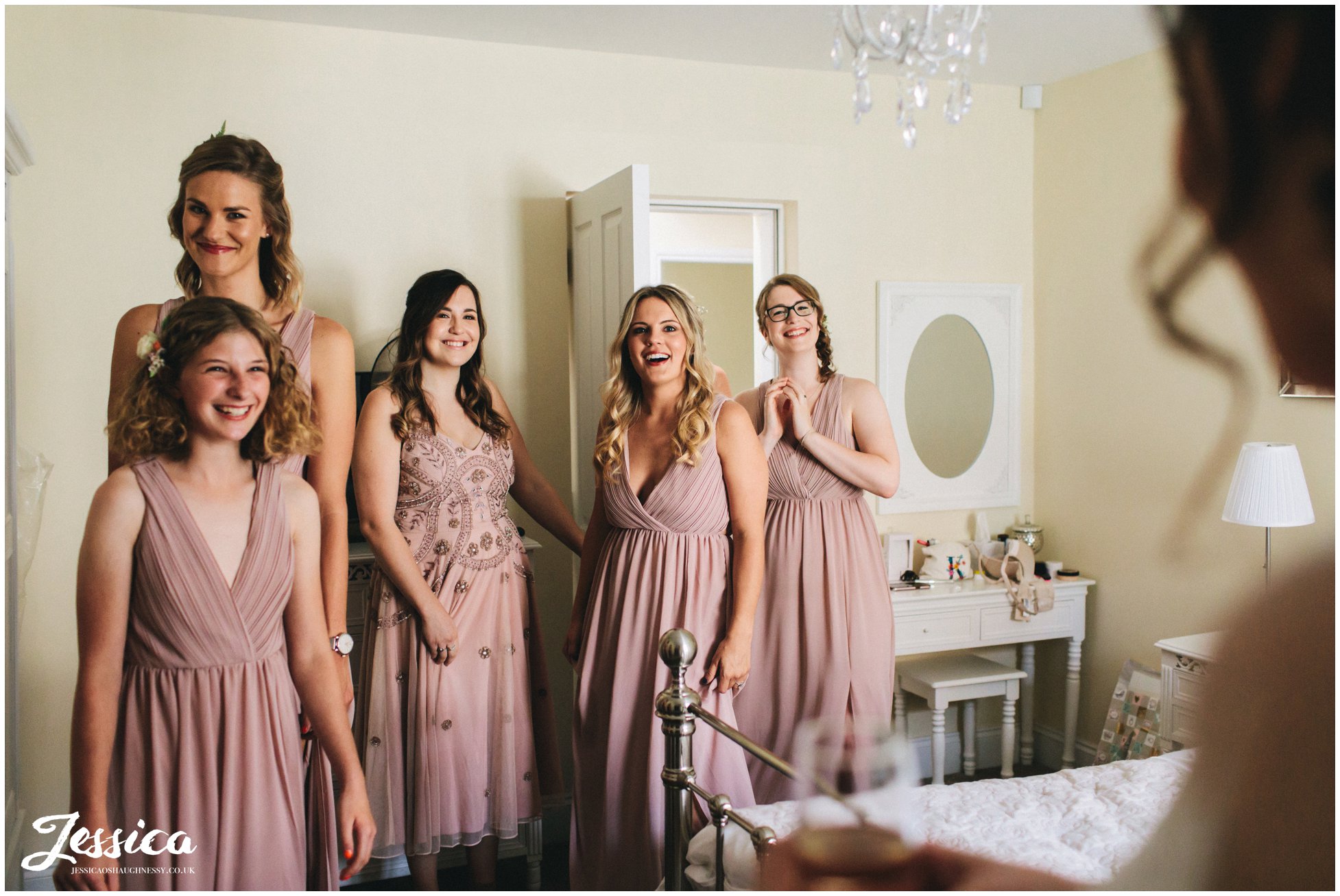bridesmaids see the bride in her dress for the first time