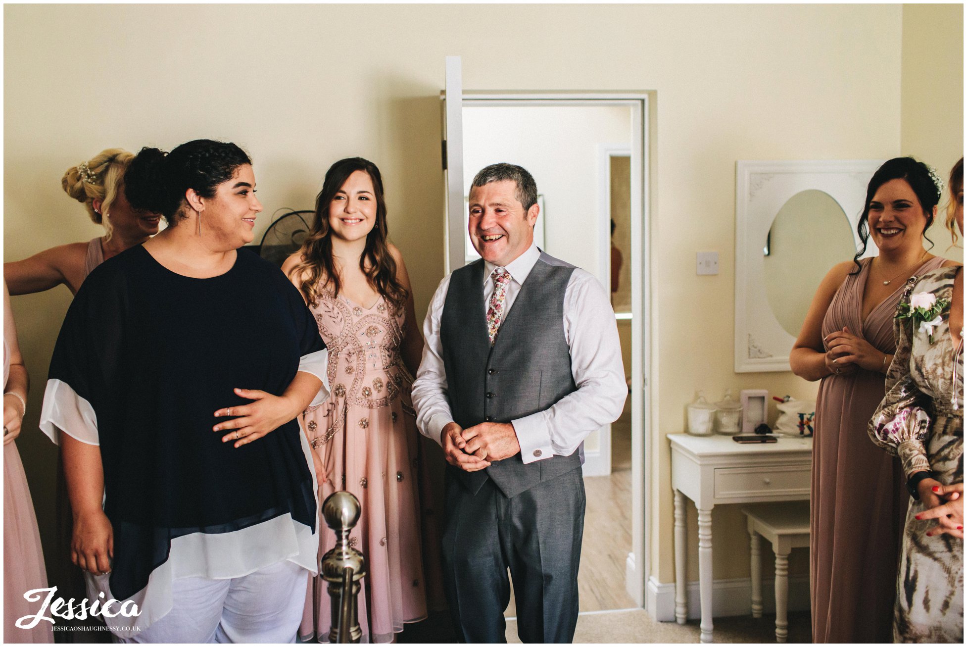 father of the bride looks emotional seeing his daughter in her wedding dress