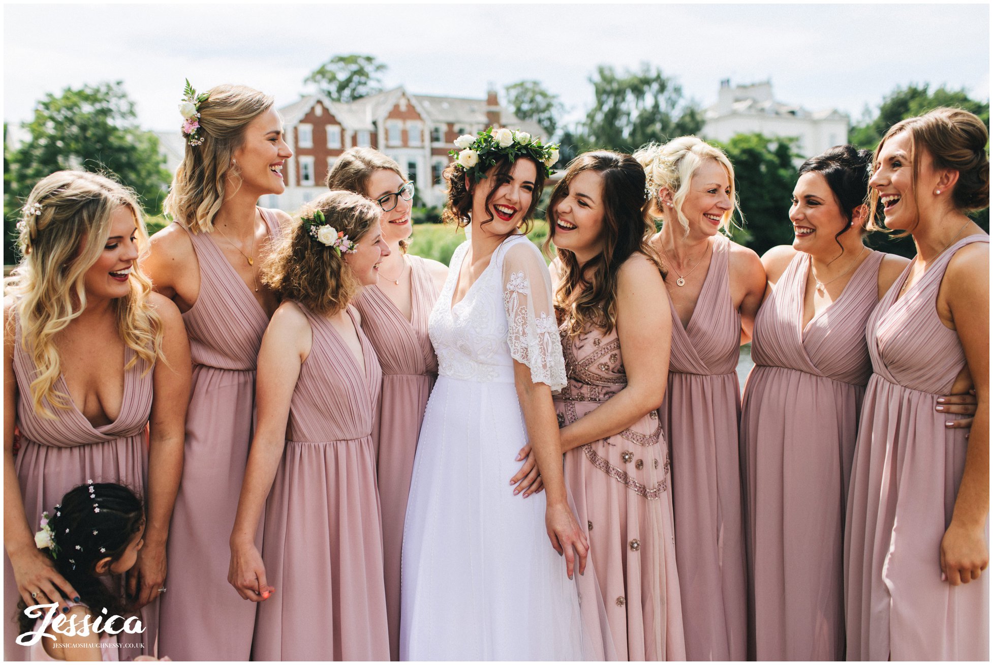 bride poses in front of the river dee with her bridesmaids