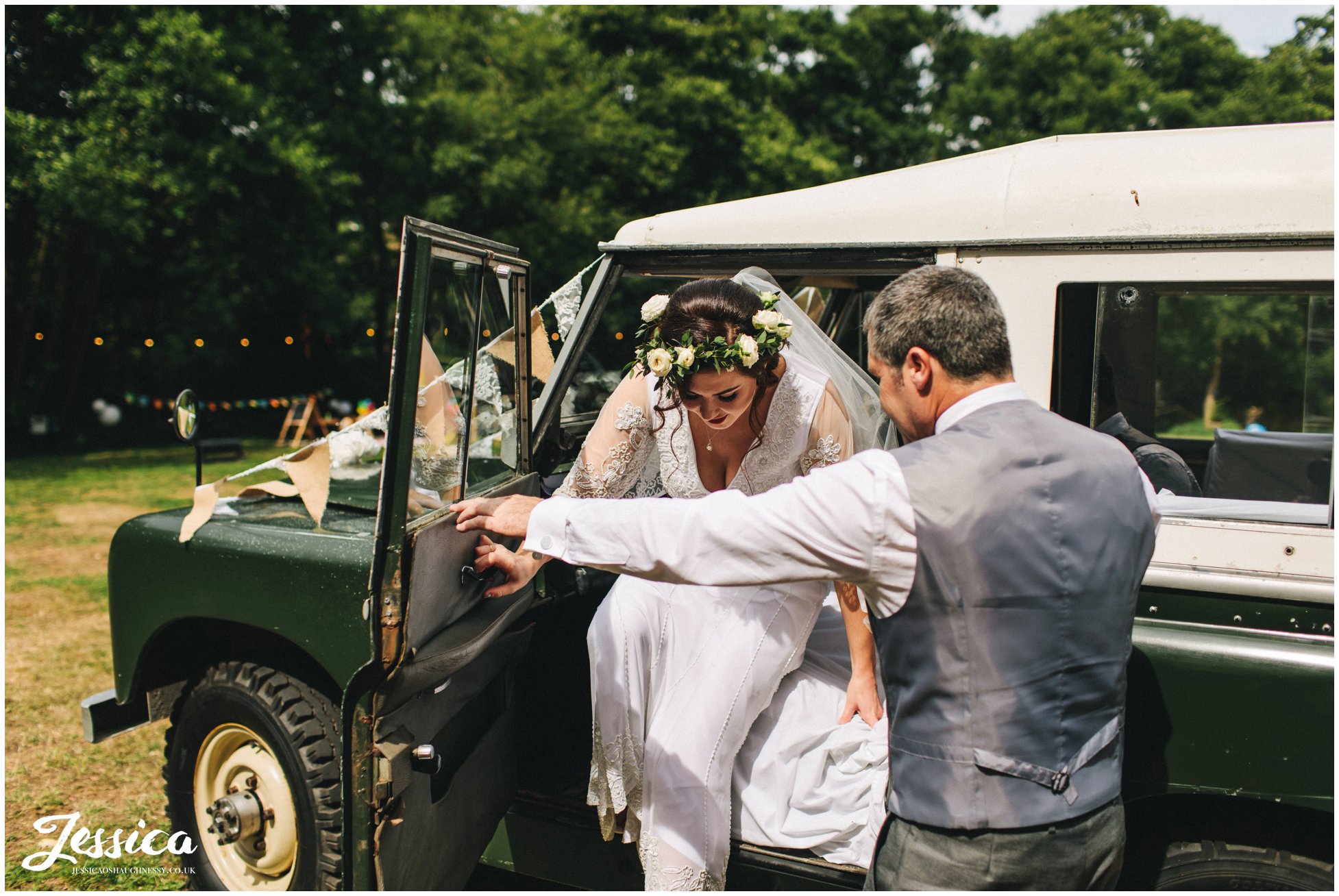 father of the bride helps his daughter out the wedding car