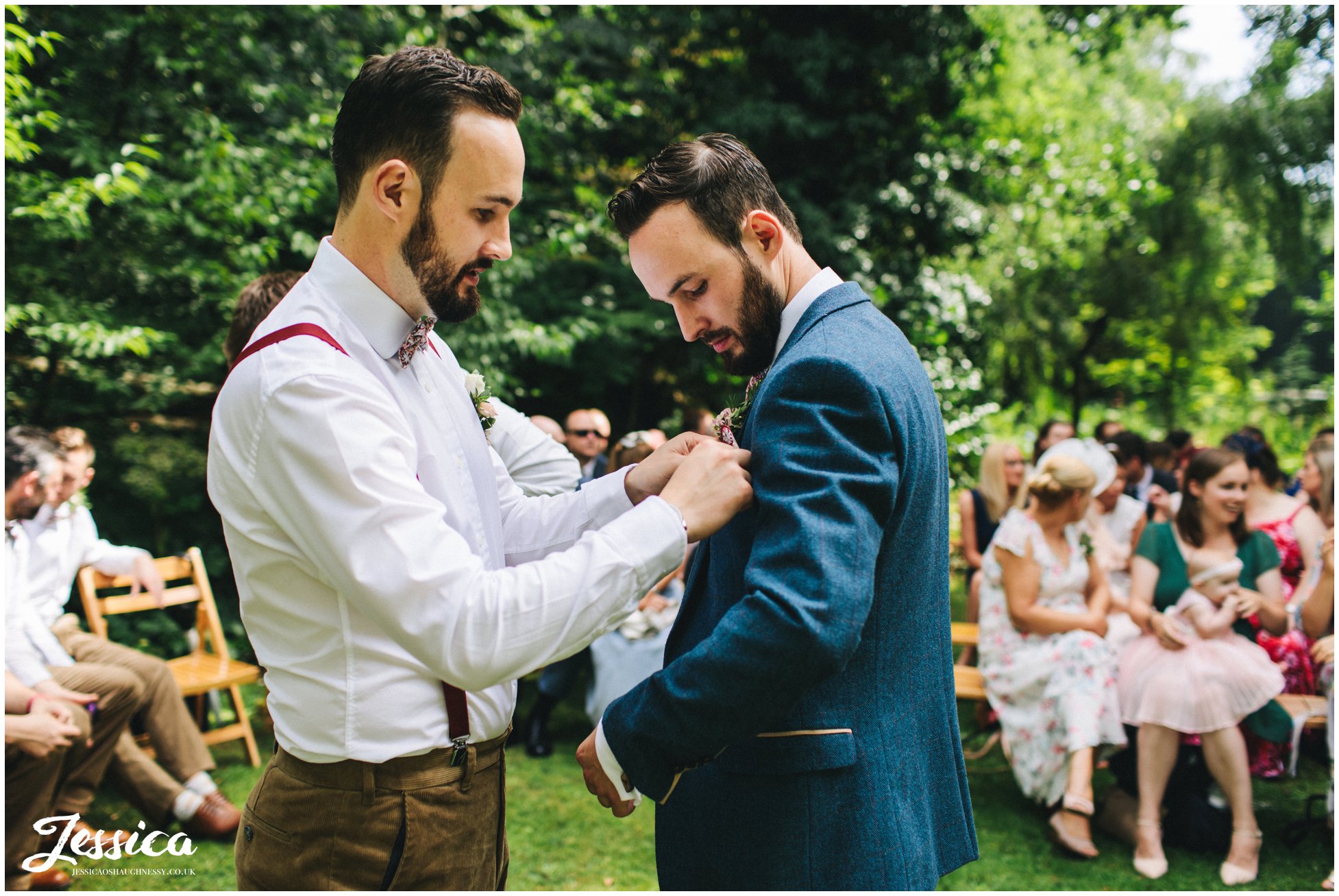 the best man smartens up the groom before the ceremony starts