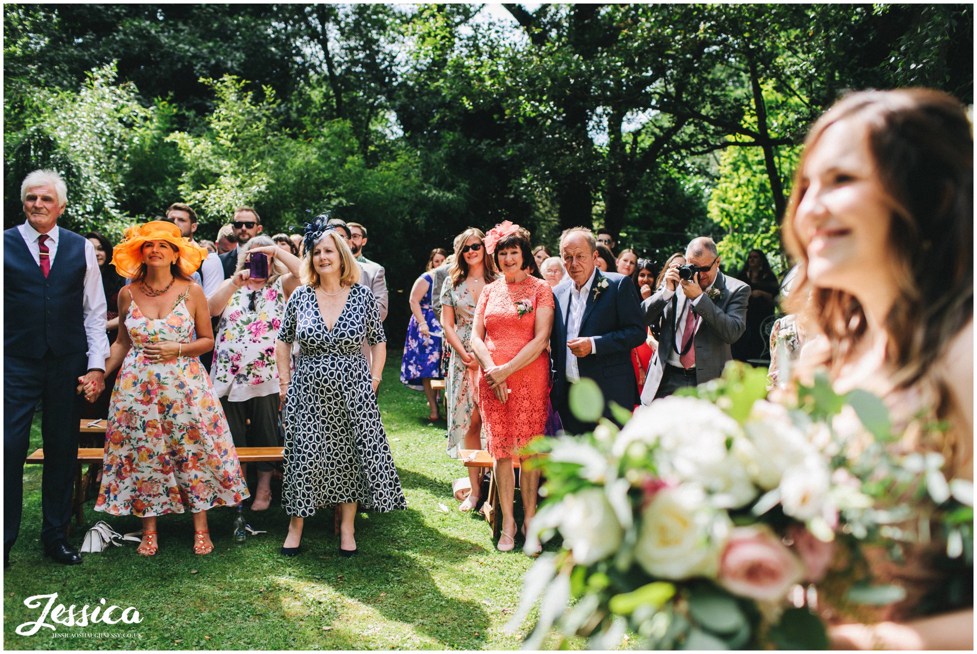 wedding guests smile during the outdoor ceremony