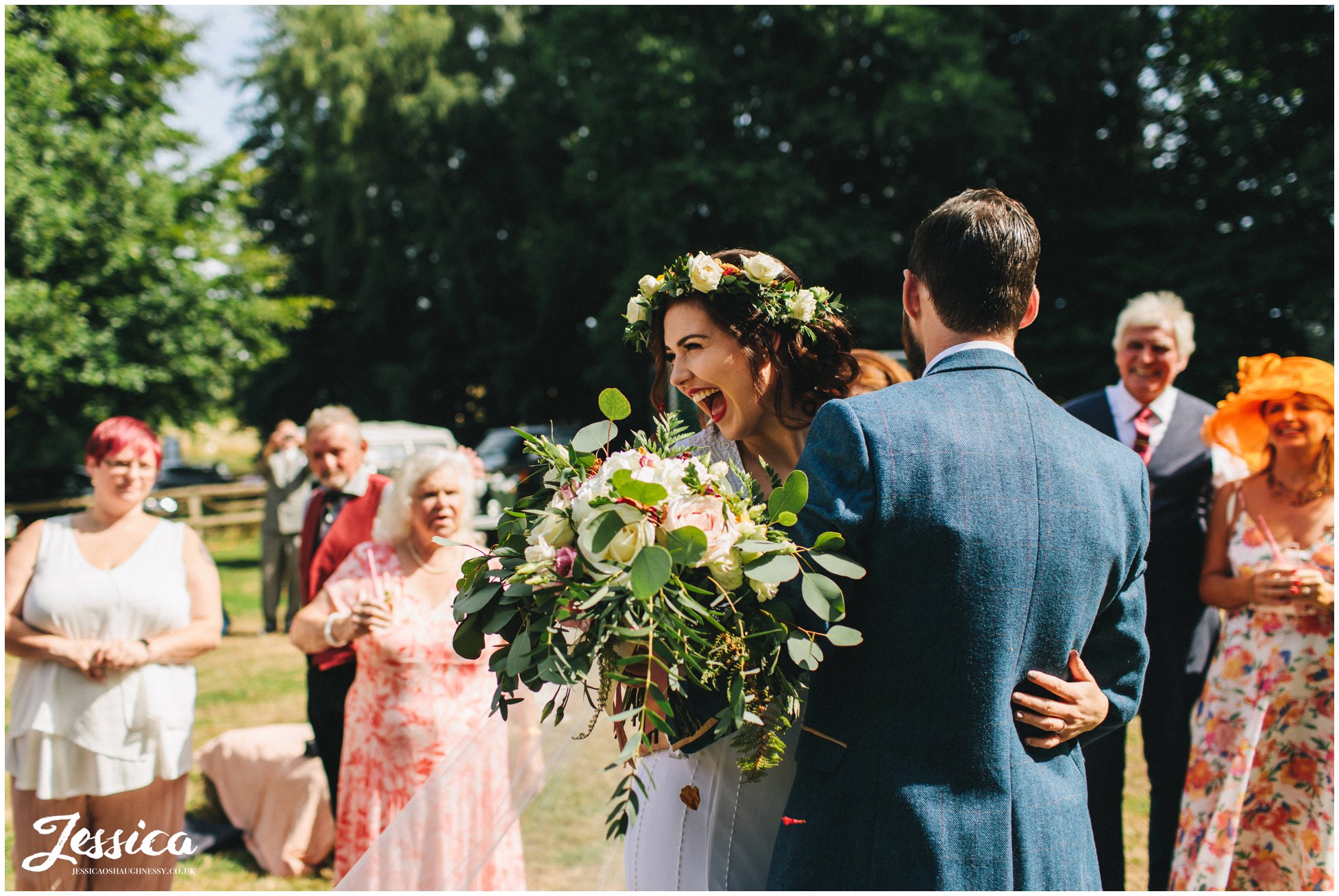 the bride laughs as the guests throw confetti over them