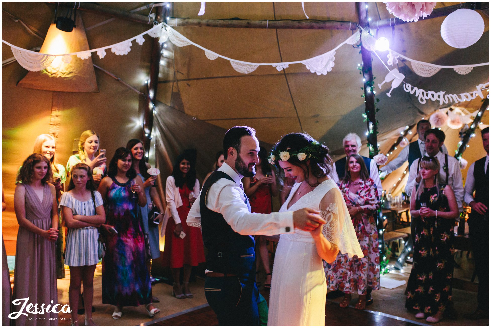 couple share their first dance together in the tipi