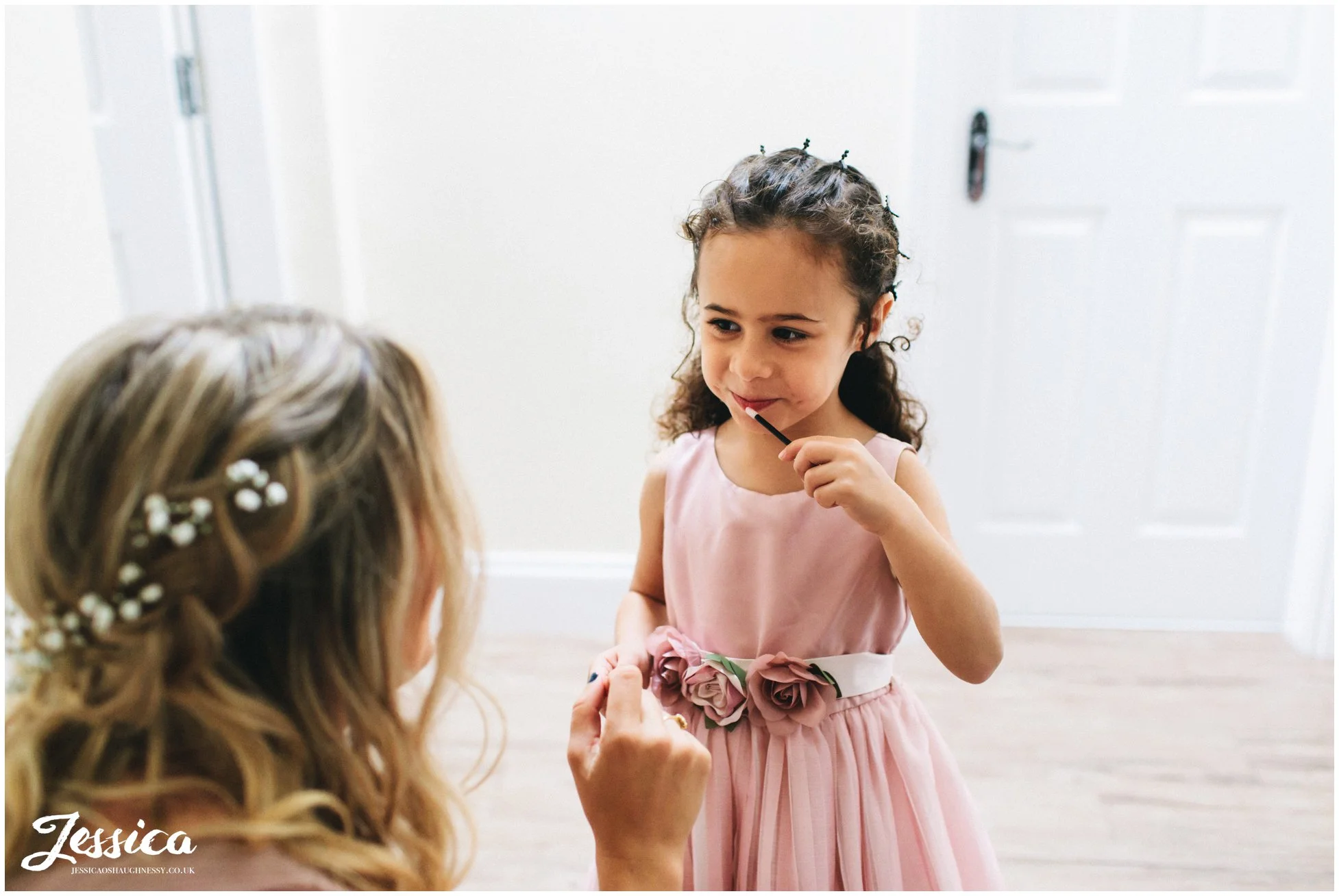 flower girl puts on lip gloss