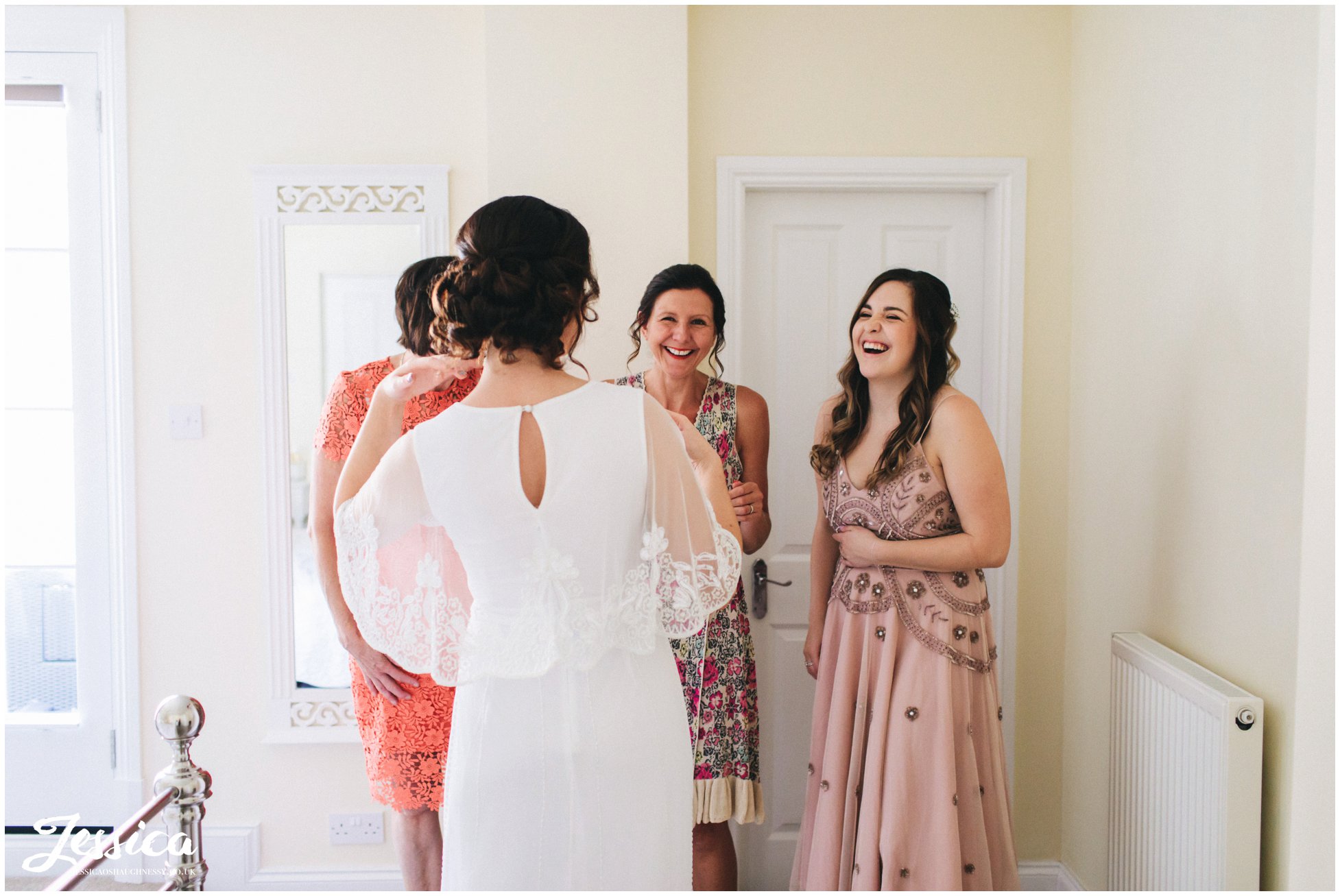 Bride's family help her into her wedding dress in chester