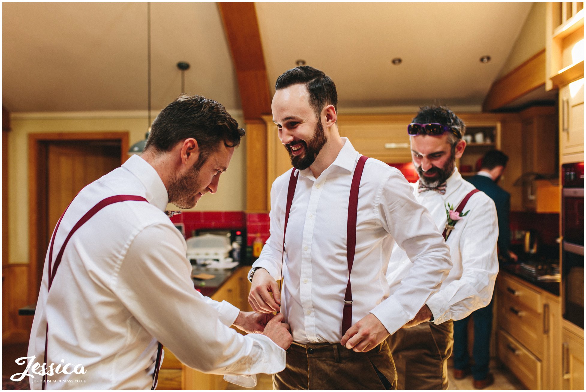 groomsmen help dress the best man