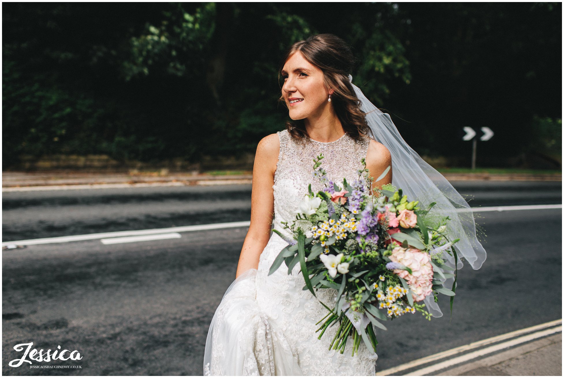 Bride waits at the road side for her bridal party to catch up