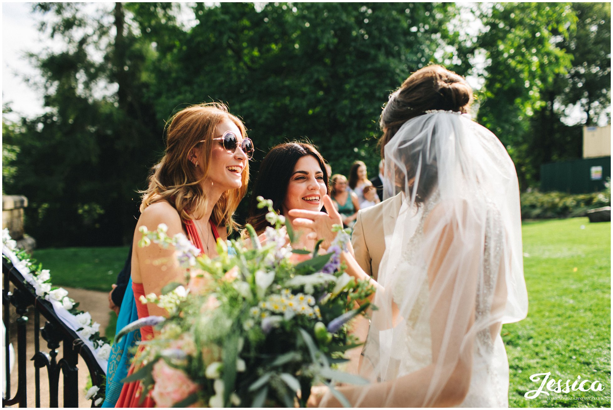 brides friends admire her in her wedding dress