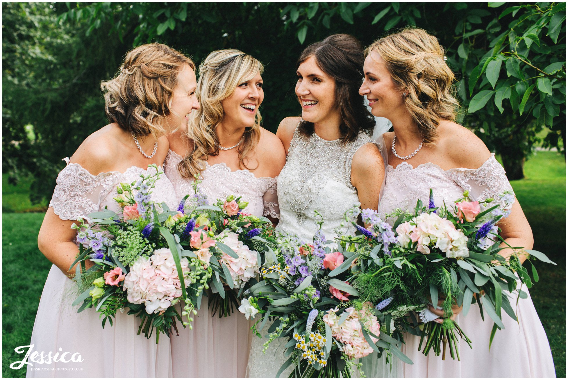 bride and bridesmaids laugh together for their group photograph