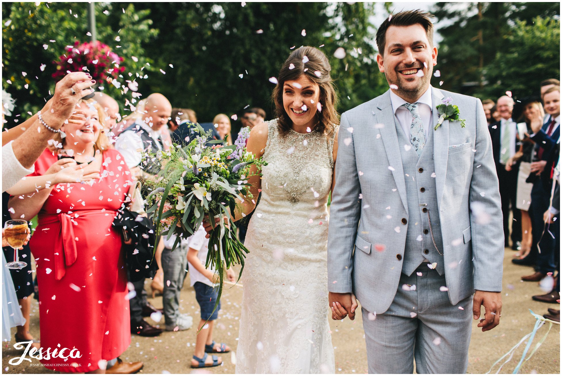 couple walk through their confetti line 