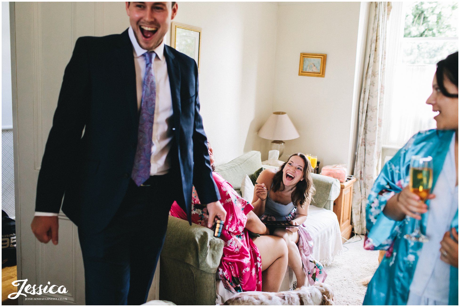 bridesmaids laughing whilst preparing for the wedding