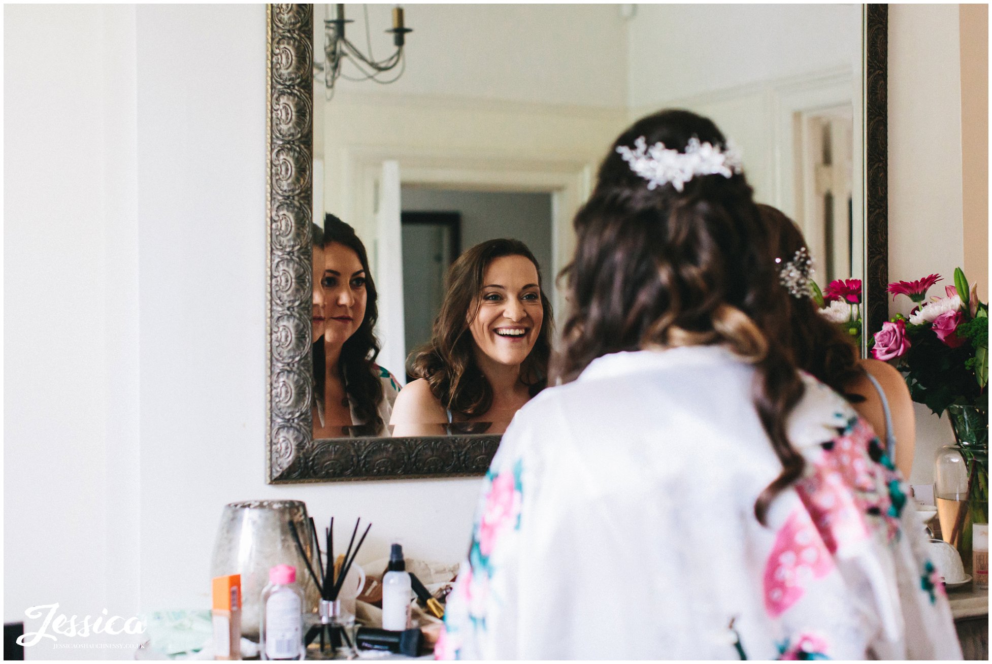 bride admires her make up with her sister