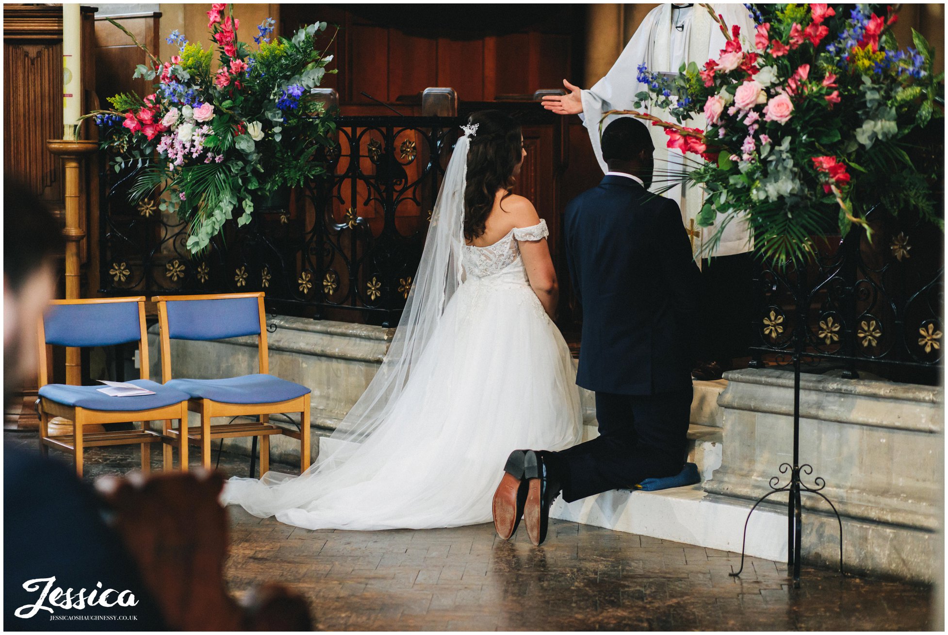 the new couple are blessed by the vicar