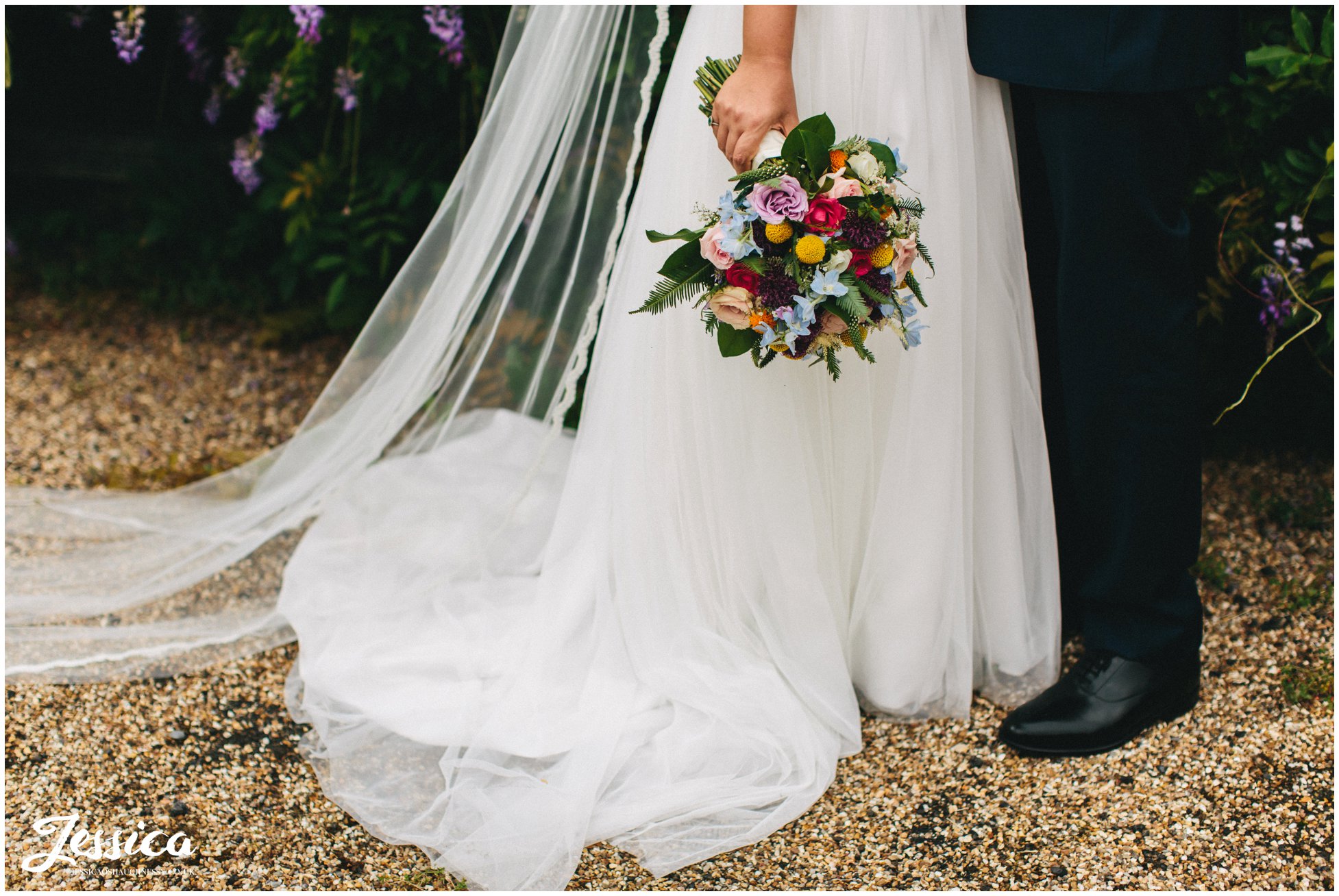 the bride holds her brightly coloured bouquet