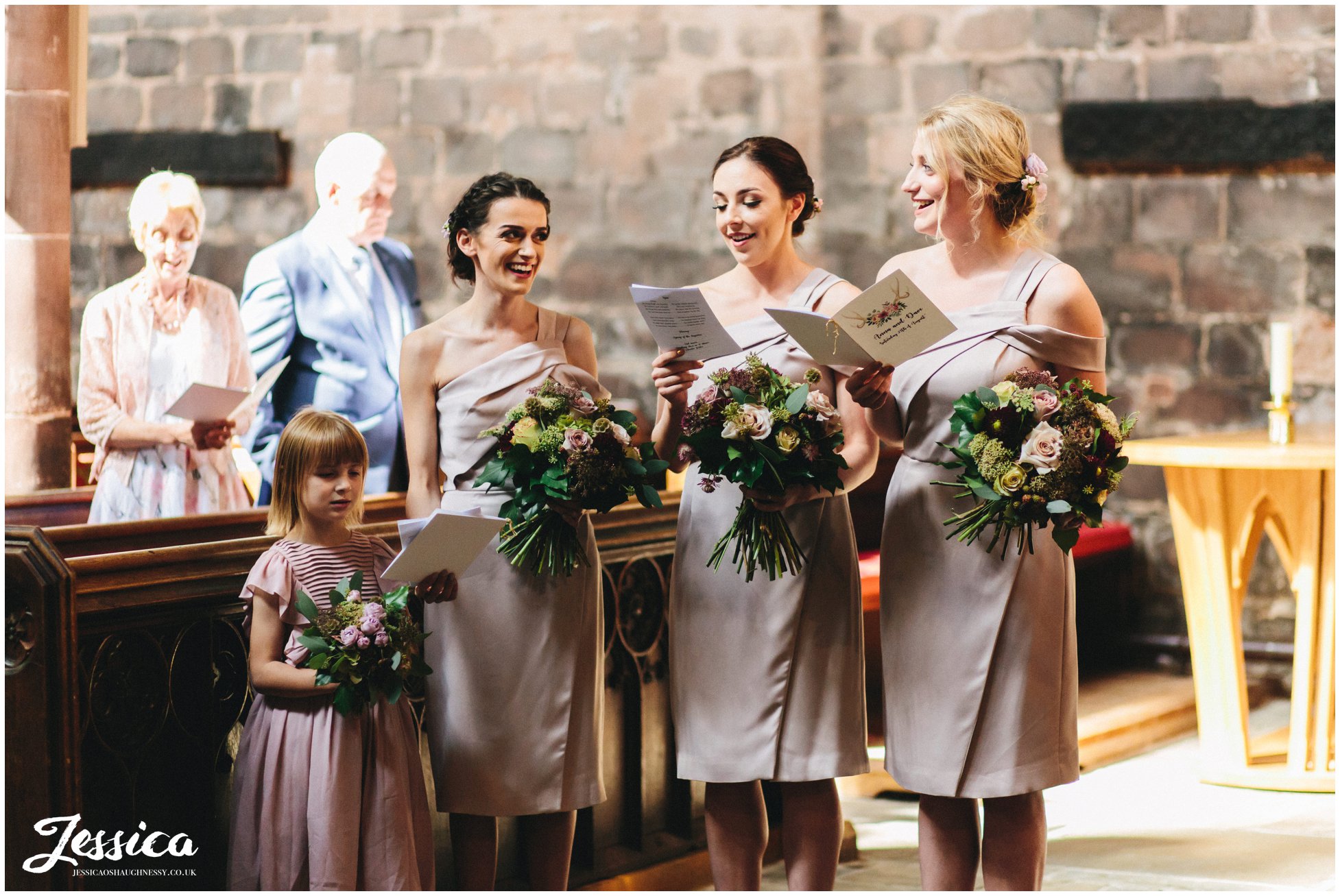 bridesmaids laugh together during the wedding ceremony in cheshire