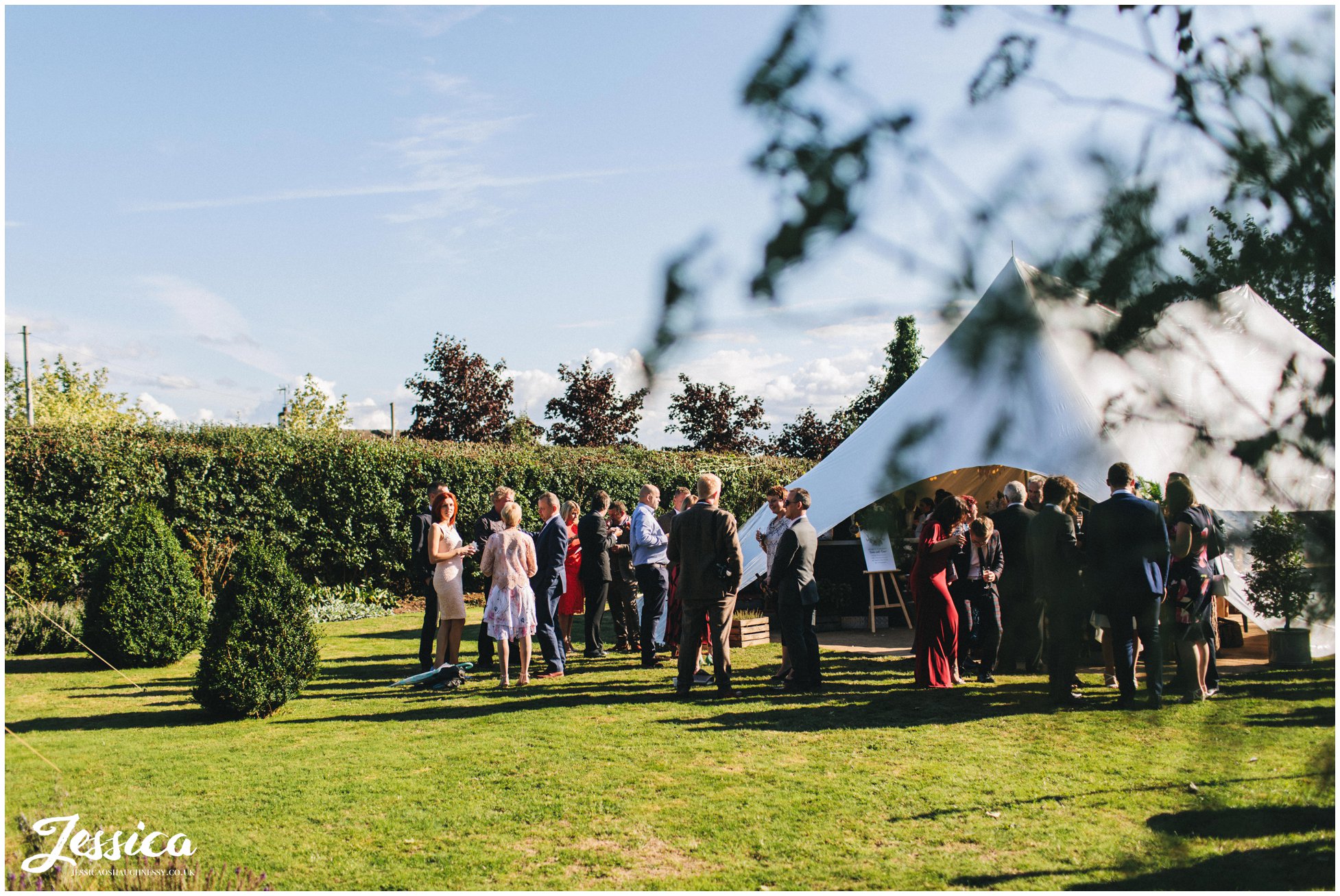 guests enjoy the sunshine at the farm wedding reception