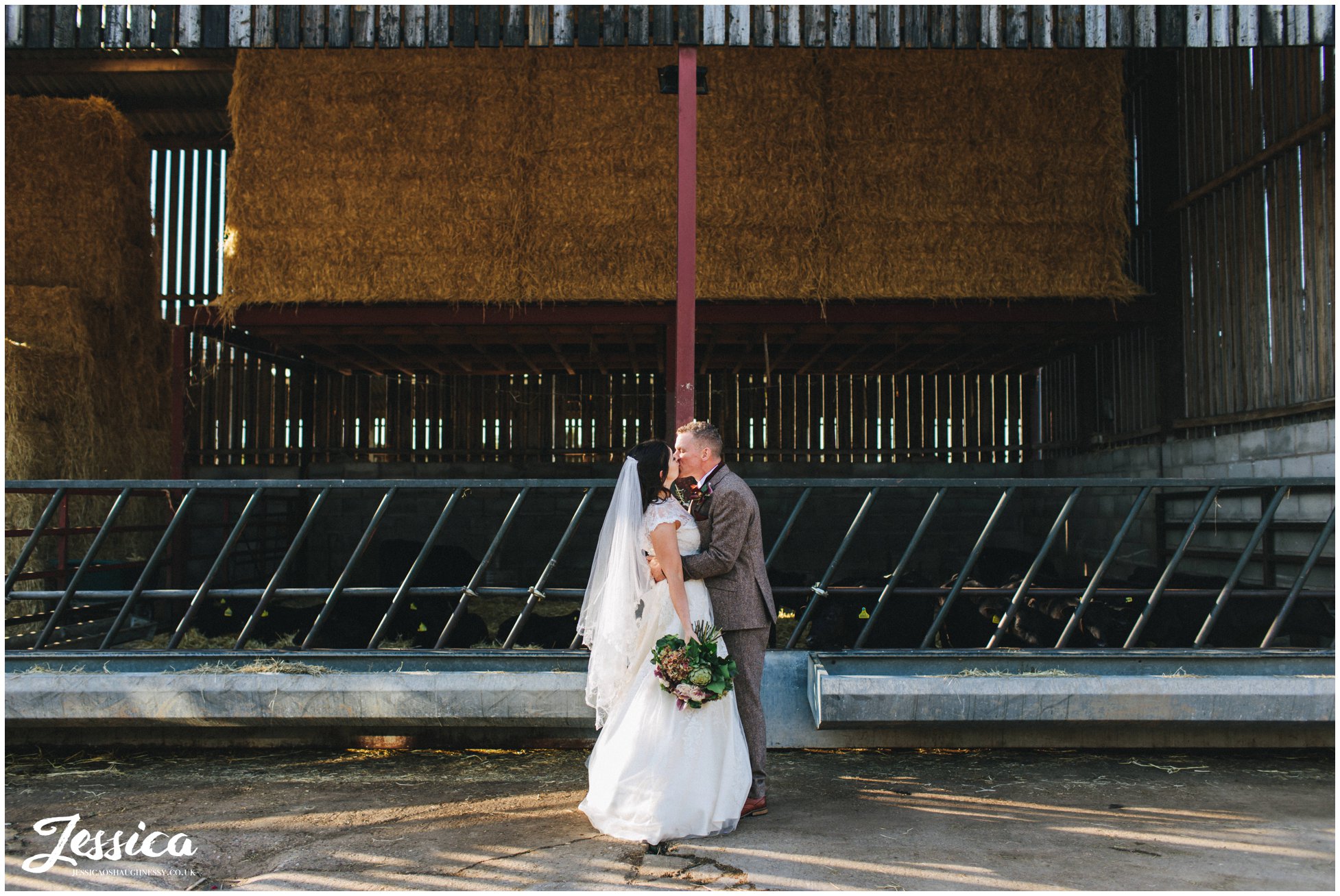 husband and wife kiss at their diy farm wedding in cheshire