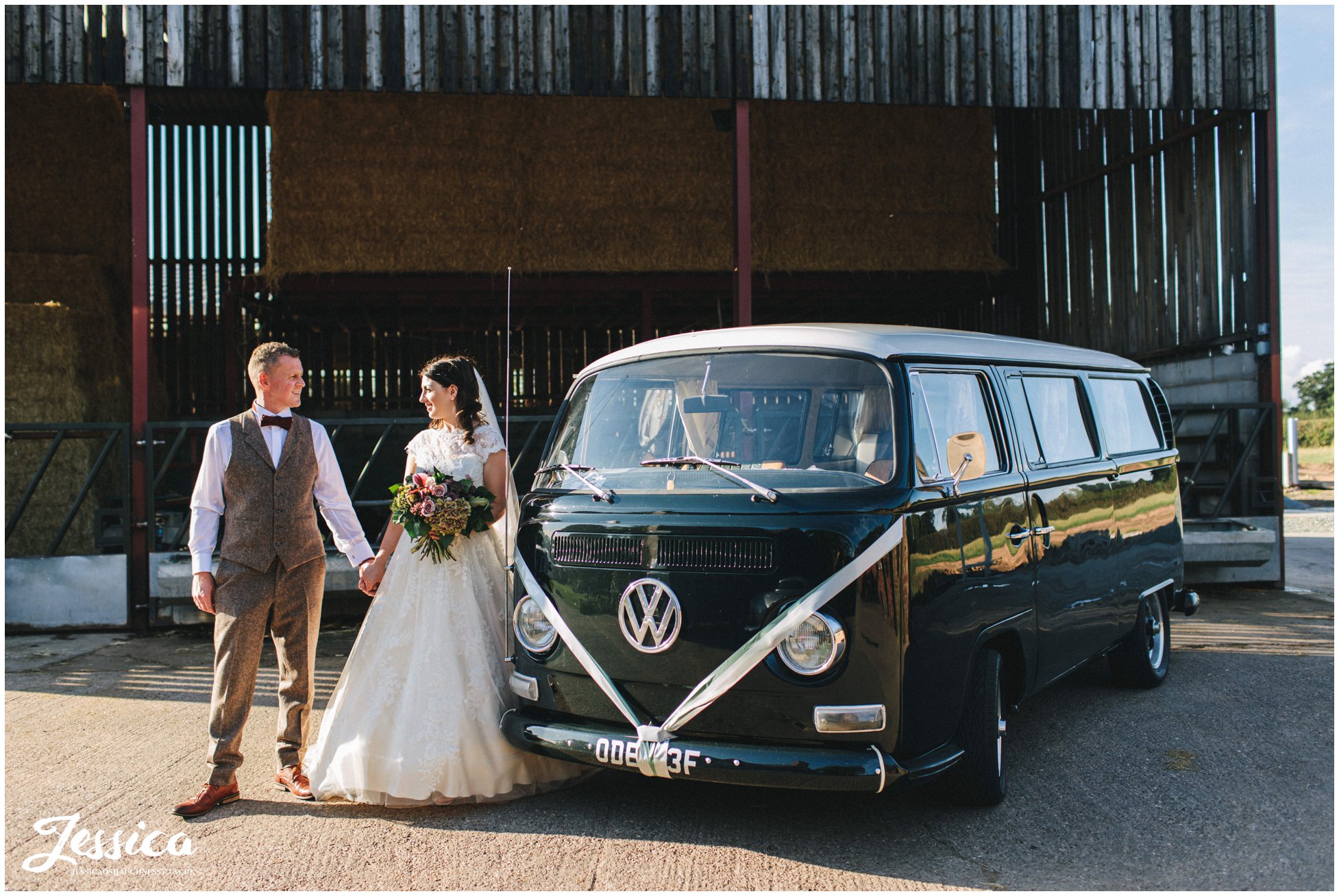 couple pose in front of vintage VW campervan