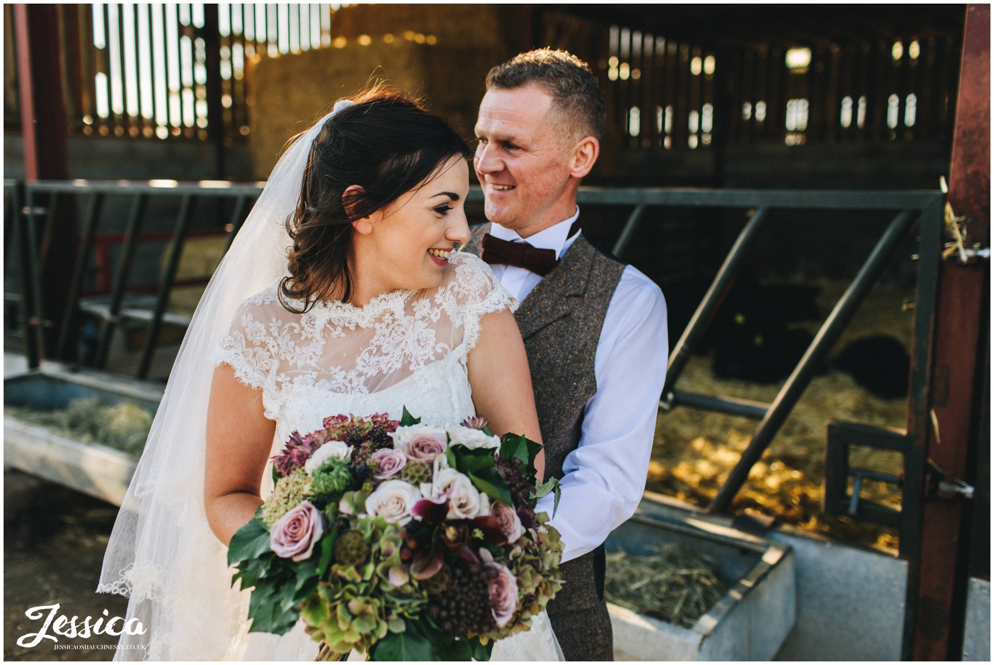 the newly wed's laughing in front of the cow shed