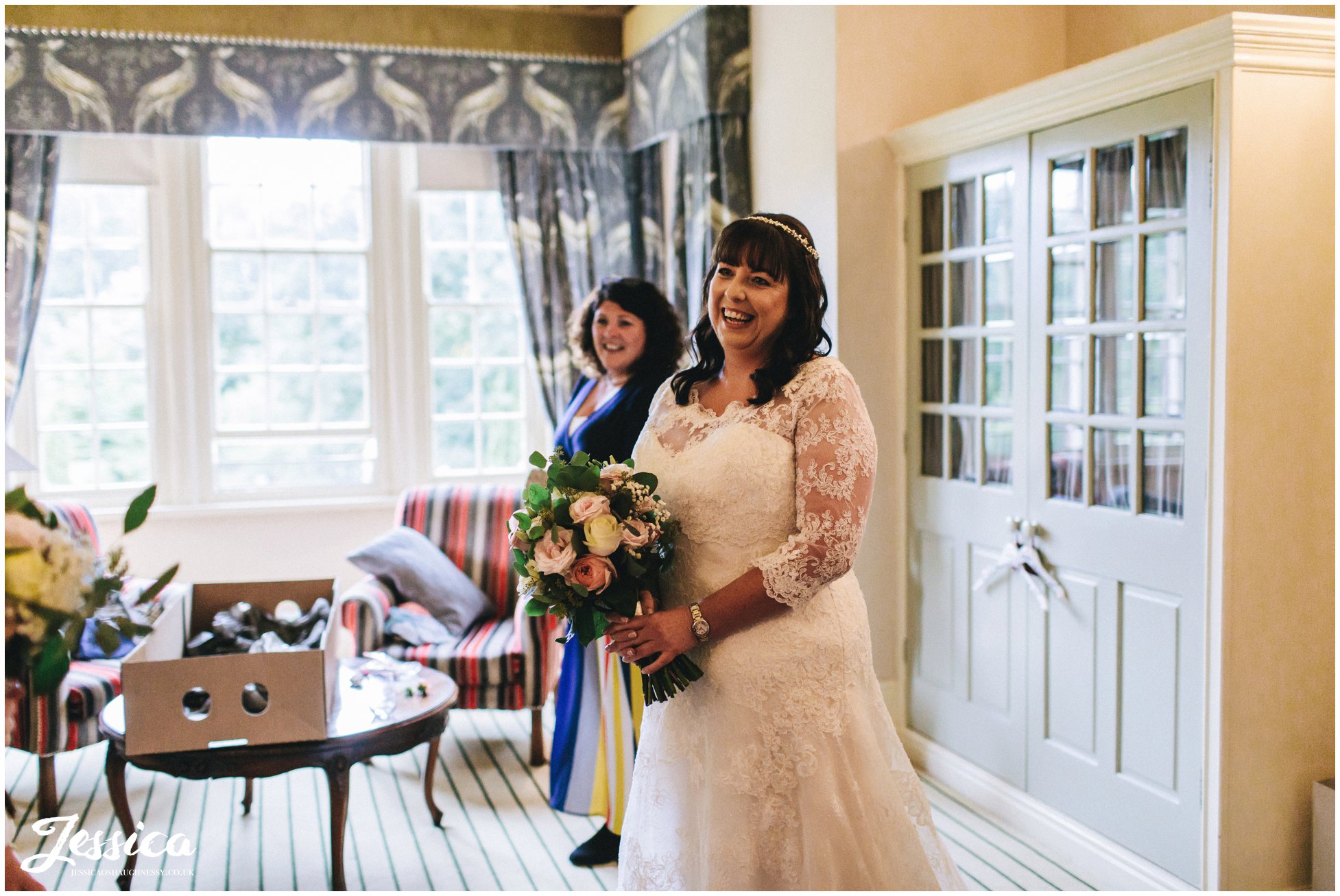 the bride smiles as she finished getting ready for the nunsmere hall wedding ceremony