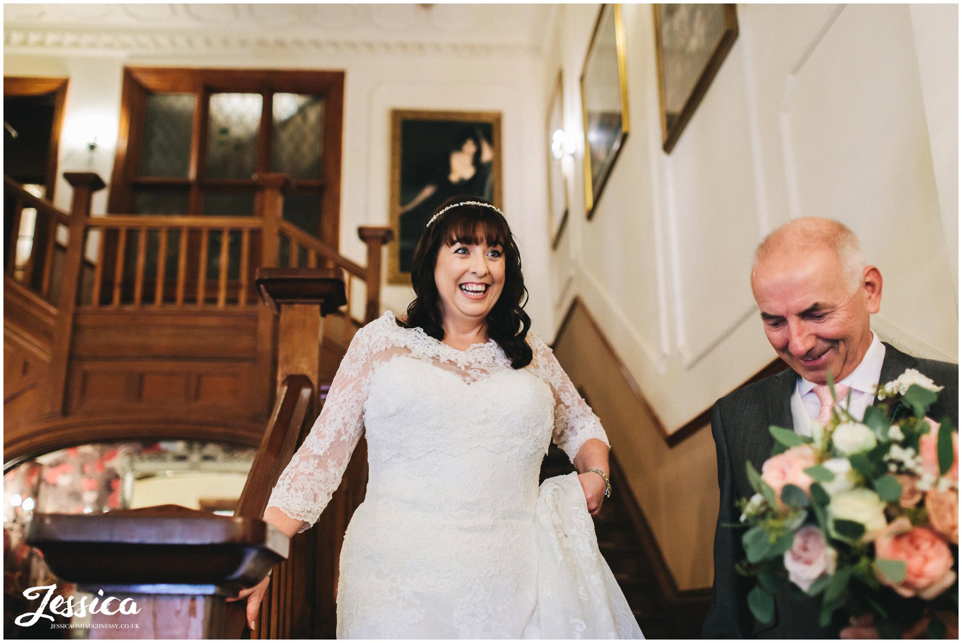 the bride walks down the stairs with her father