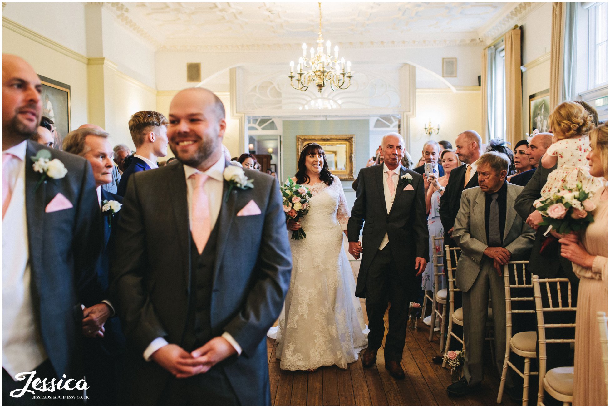 the bride walks down the aisle with her dad at nunsmere hall