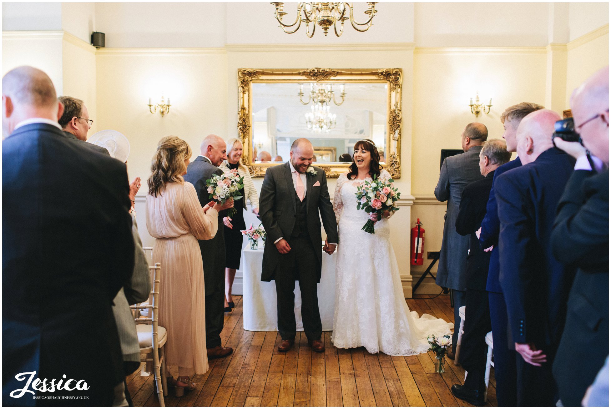 the newly wed's laugh as they are about to exit the ceremony room