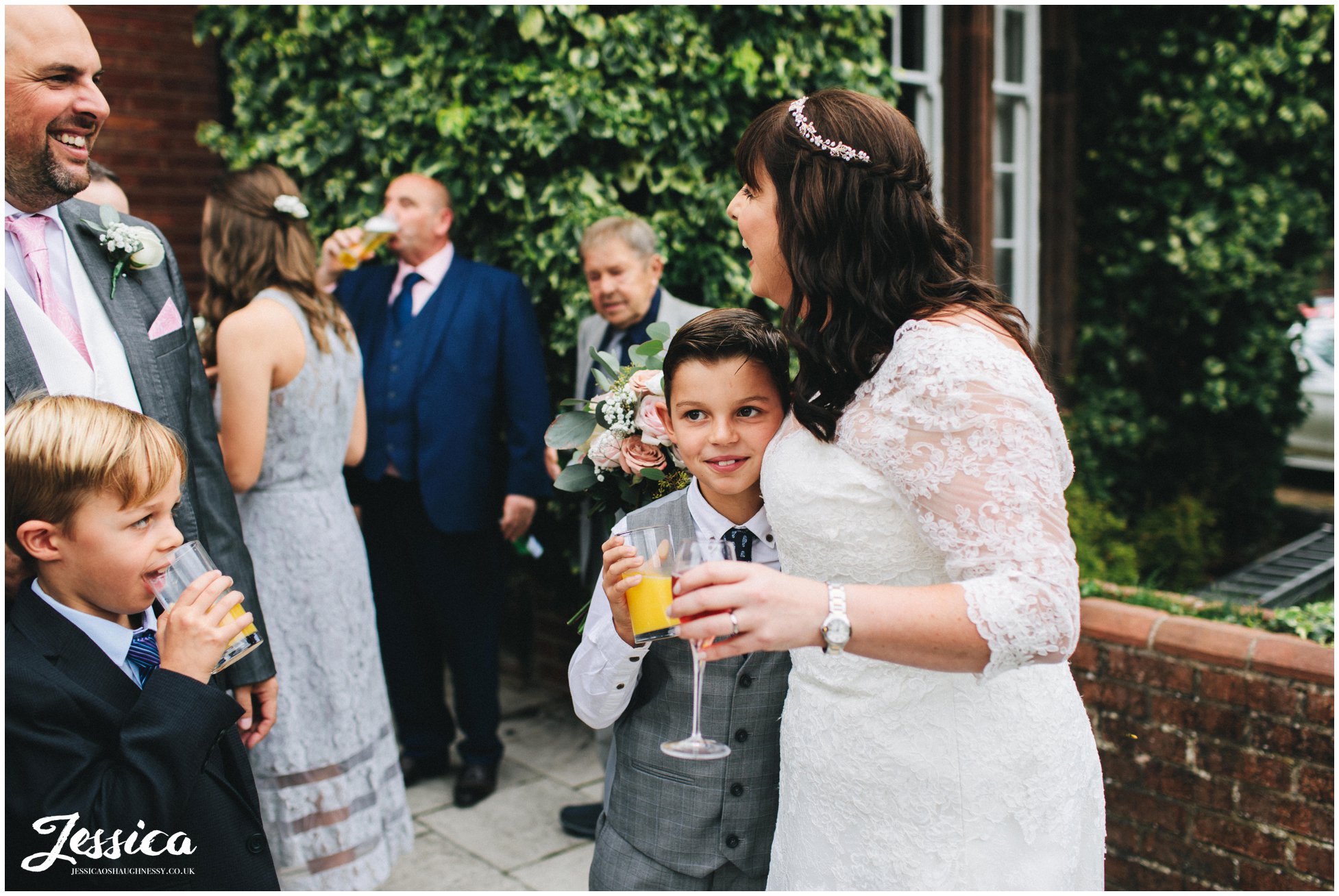 the bride hugs a child at her nunsmere hall wedding