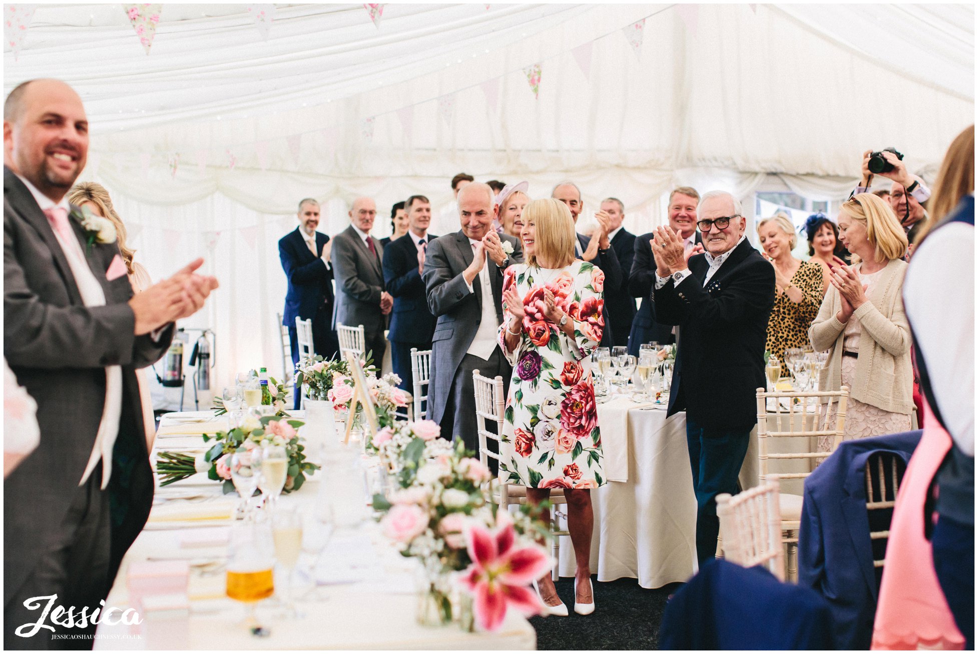 wedding guests clapping as the new couple make their entrance 