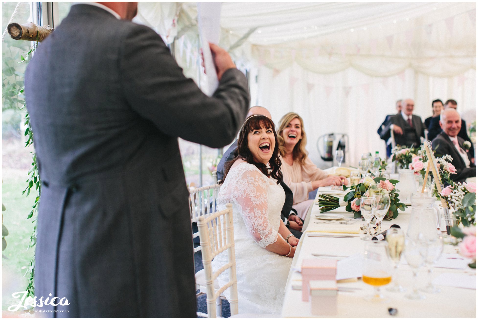 the bride laughs as the best man gives his speech