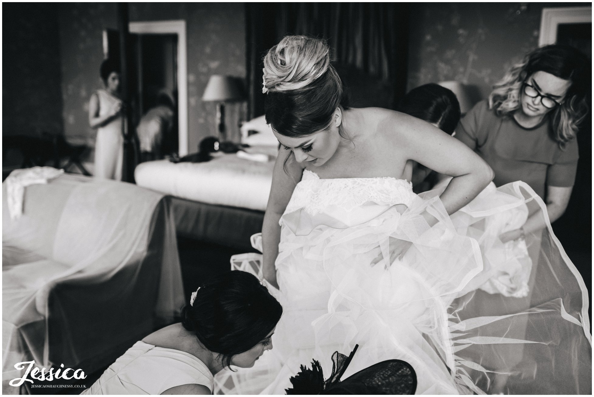 everyone helps the bride into her wedding dress at stubton hall, newark