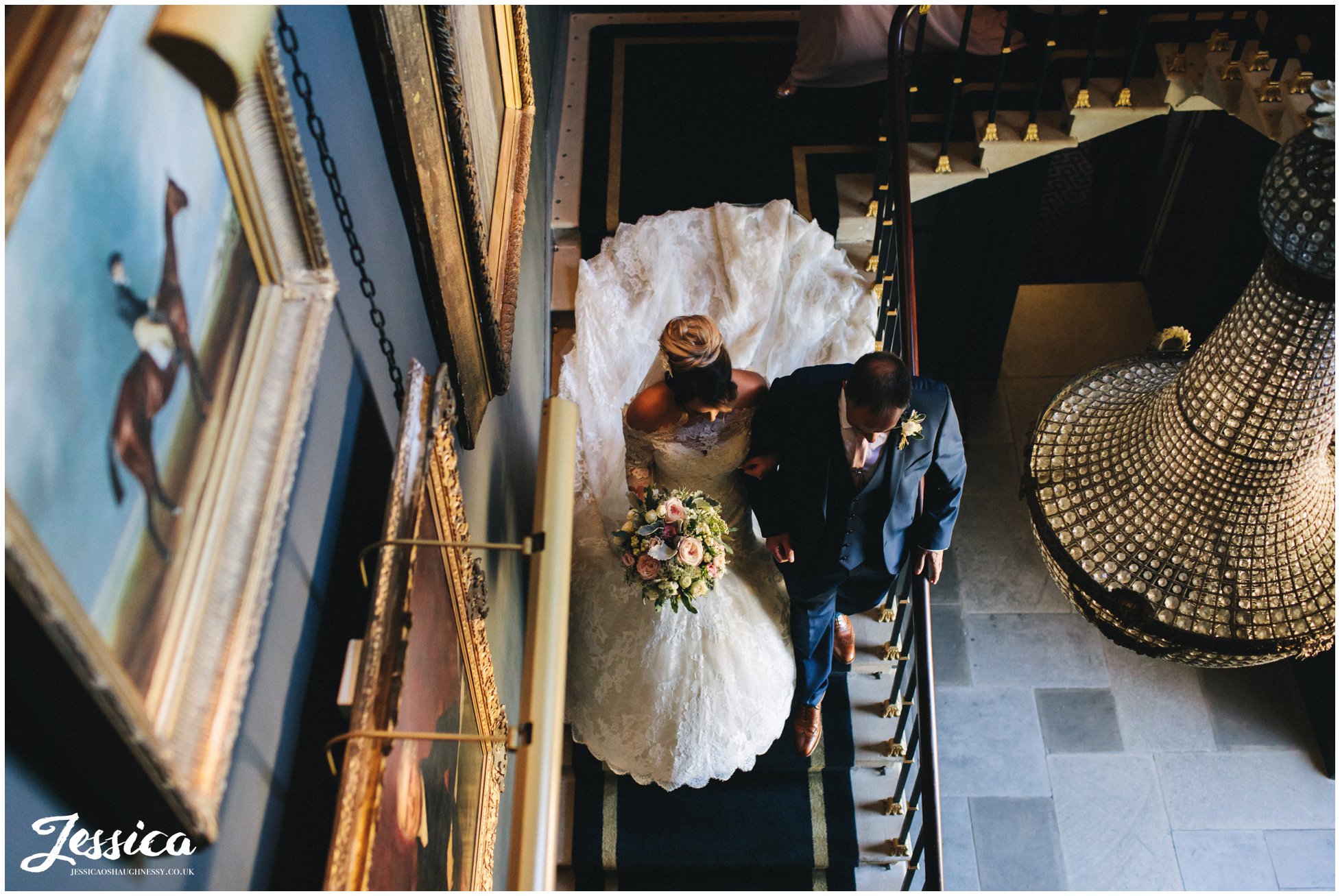 the bride & her father walk down the stairs