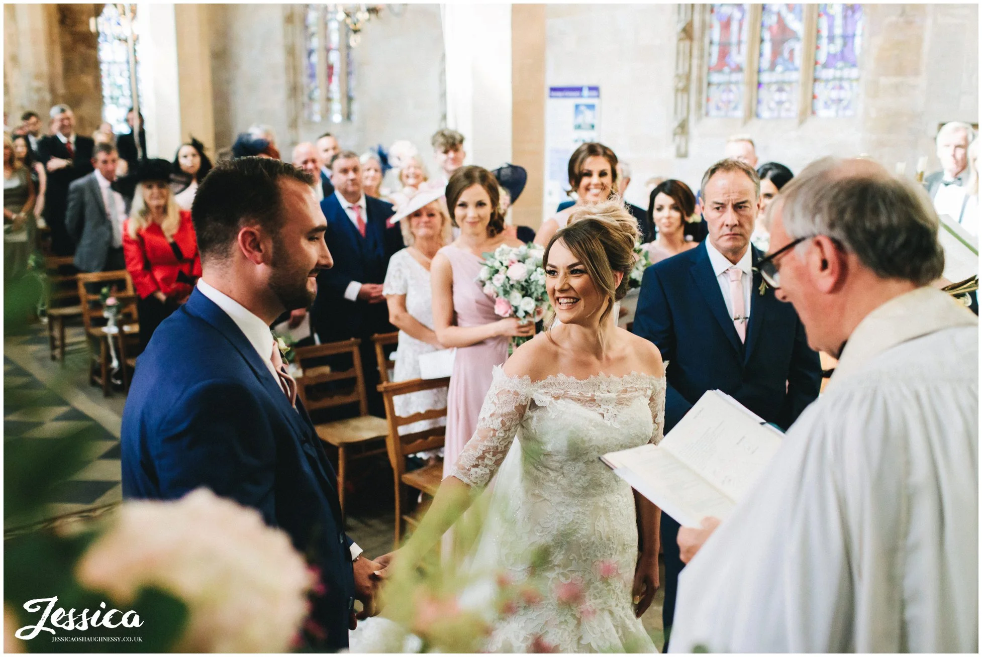 the bride smiles at her husband to be during their wedding ceremony