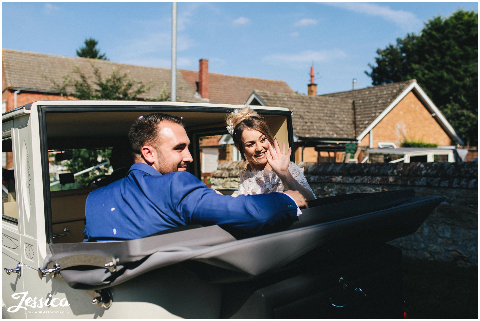the bride & groom wave to guests as they drive off to stubton hall
