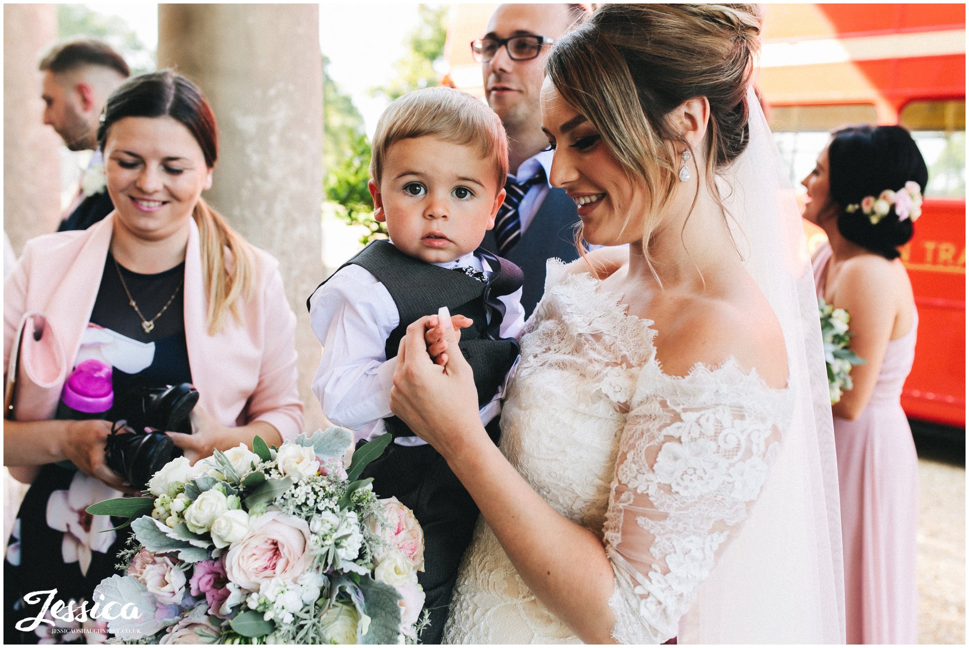 the bride holds a little boy at stubton hall in nottinghamshire