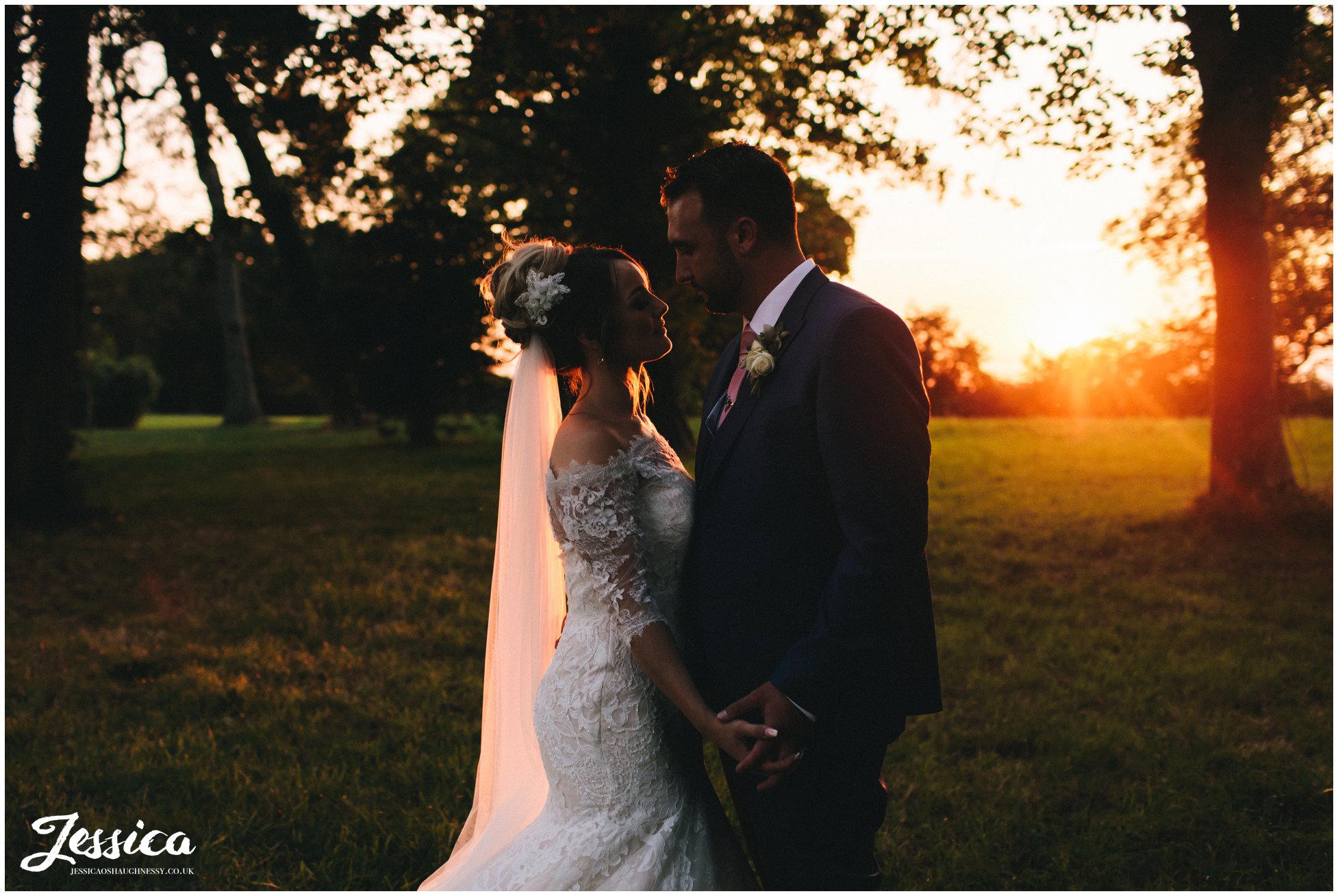 the couple hold hands as the sun goes down