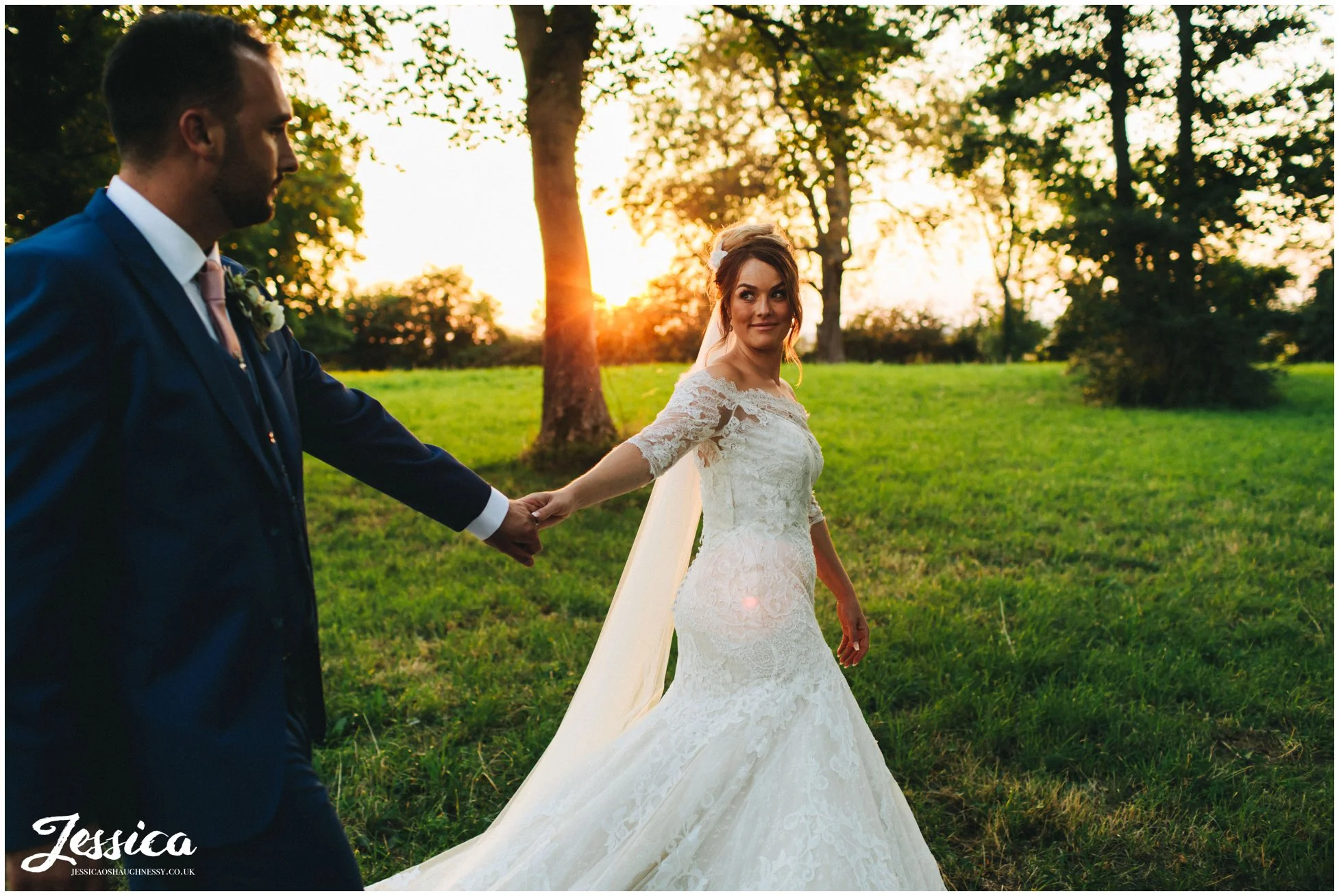 the pair walk through the trees in the sunlight