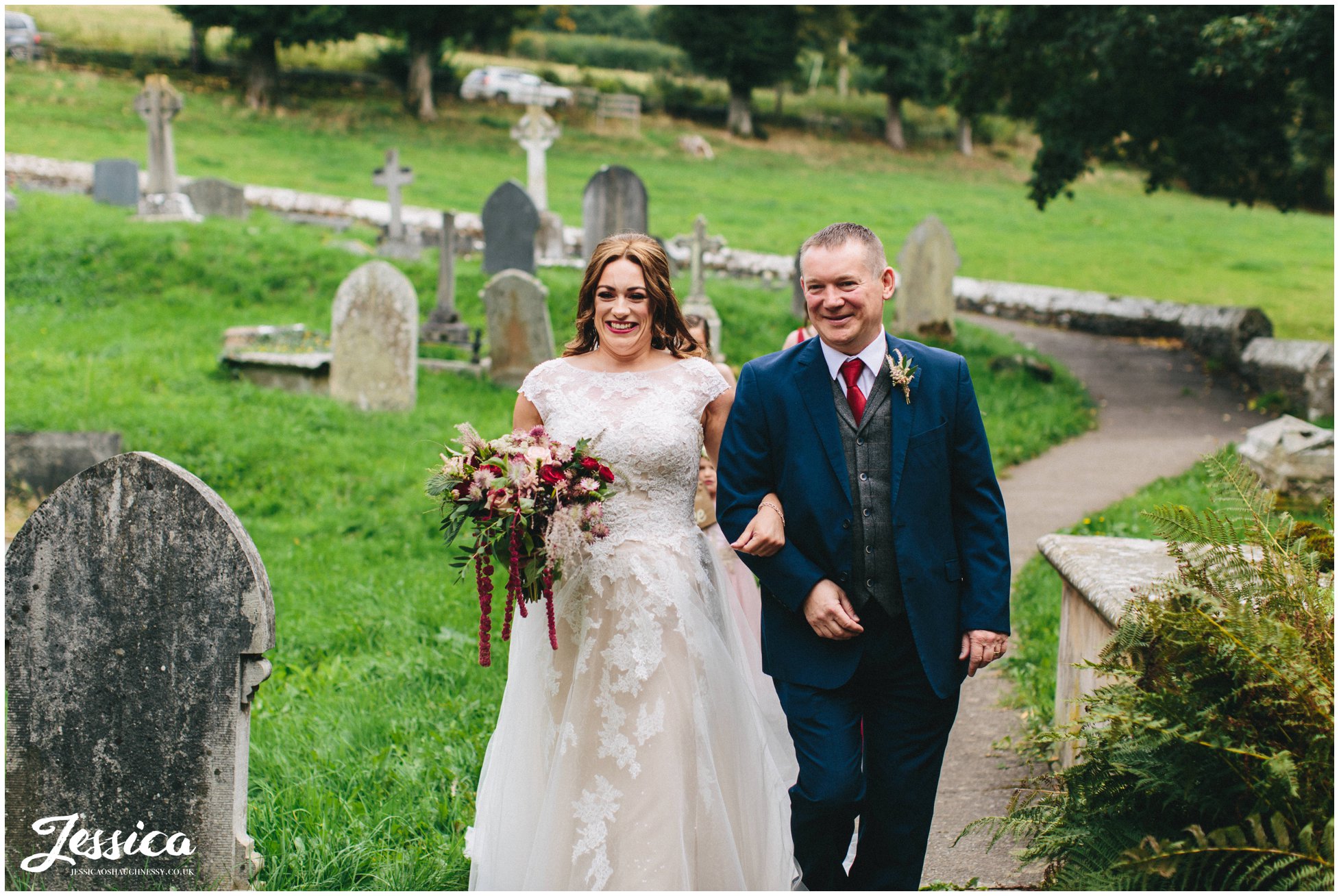 the bride and her father walk to the church entrance 
