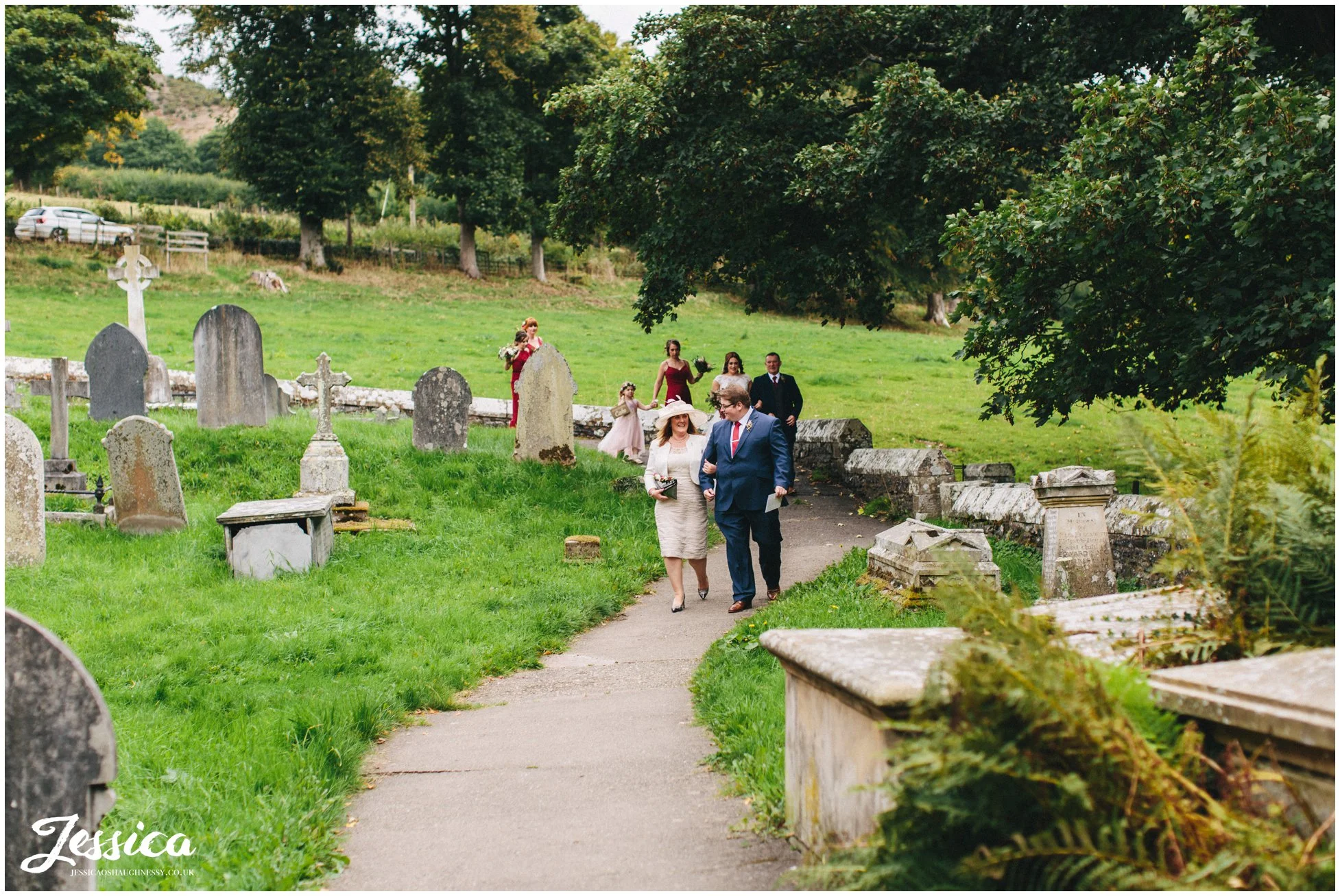 the bridal party walk down the church path